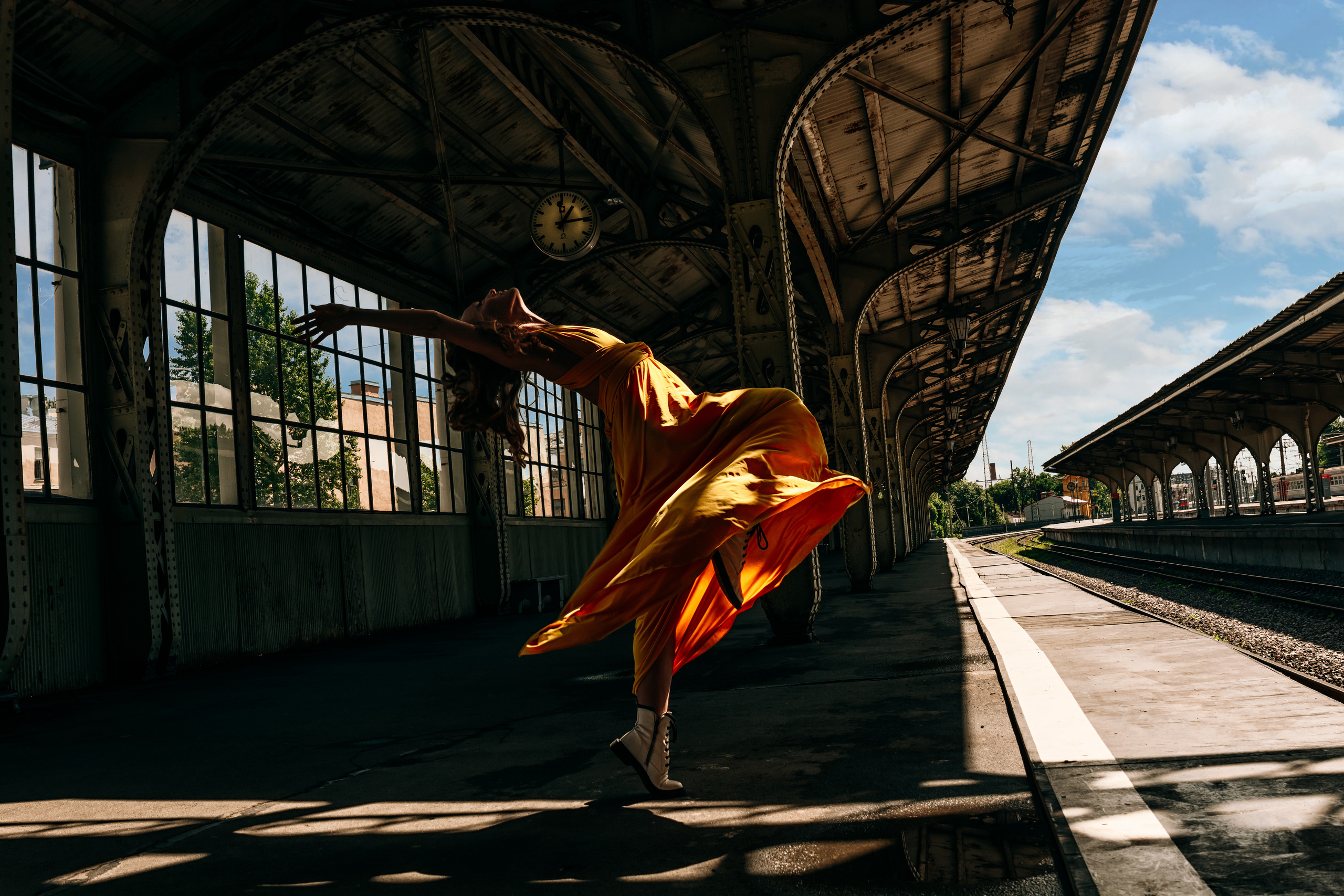 Яркая и стильная девушка, танцующая в желтом платье на Витебском вокзале.