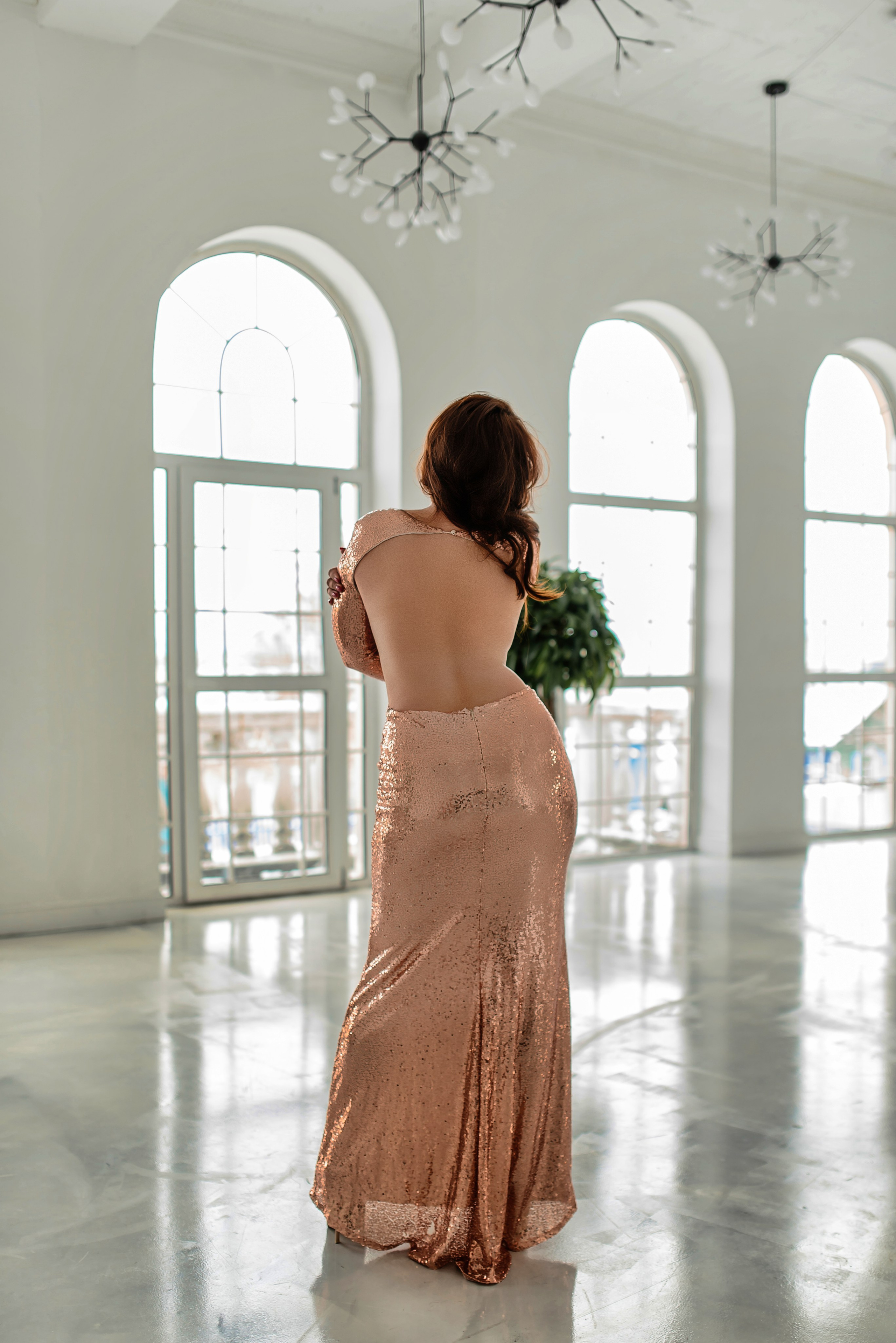 Девушка в золотистом платье с открытой спиной облегающее силуэтное