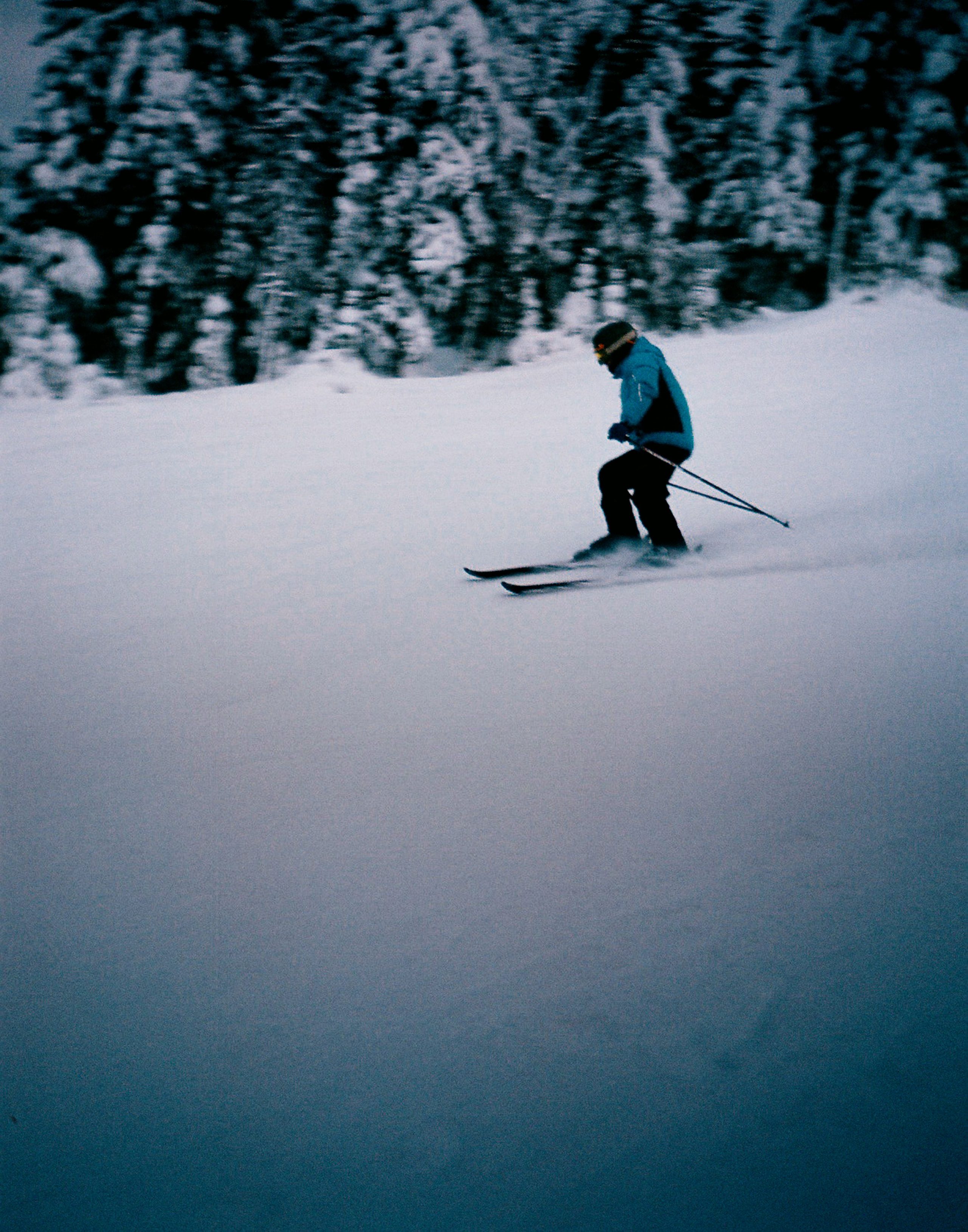Горнолыжник входит в резкий поворот на снежной трассе