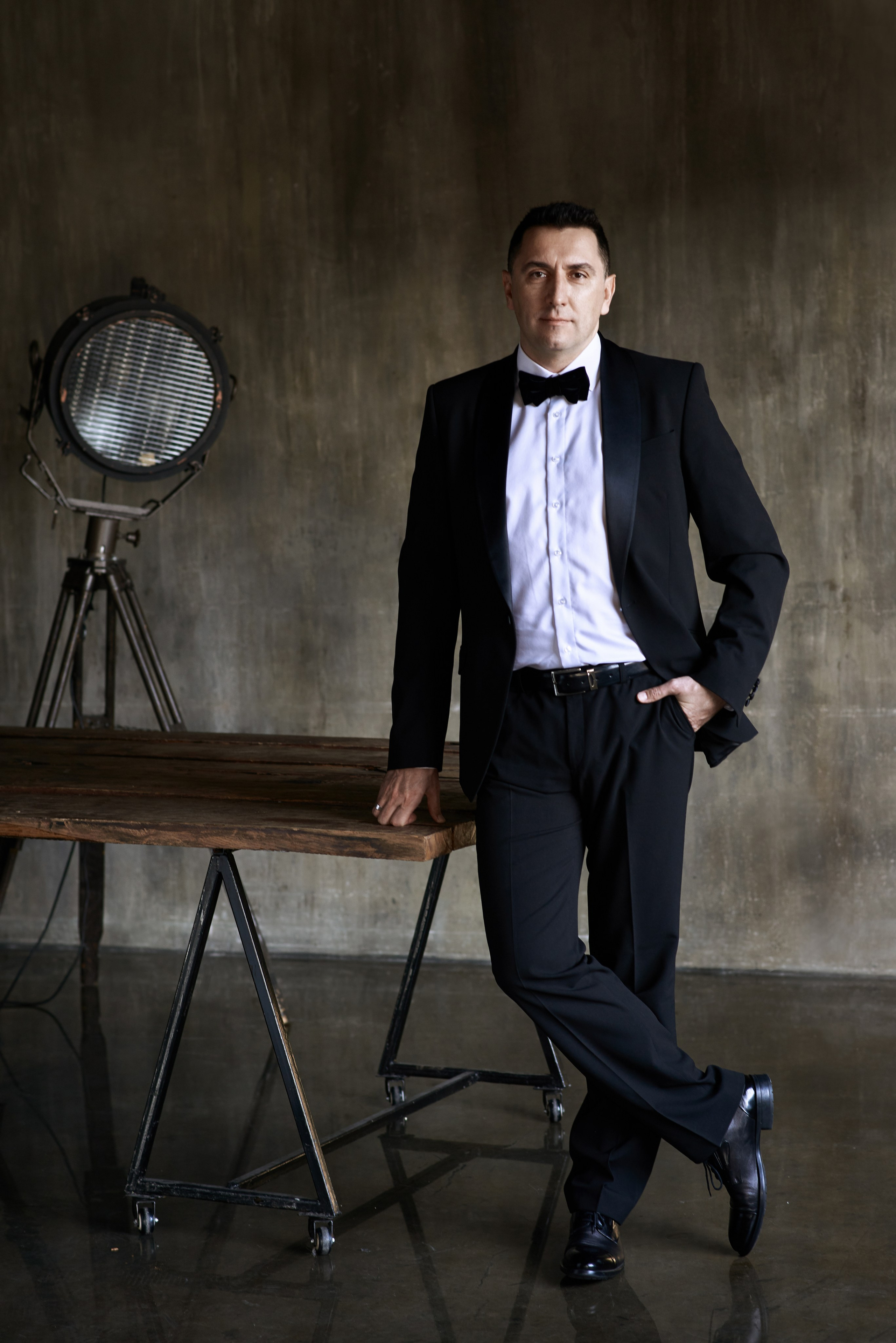 Фотосессия мужчины в смокинге с бабочкой в лофт студии