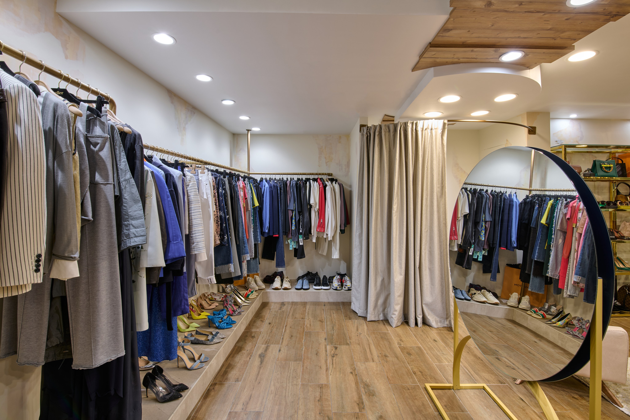 Длинный проход с одеждой, зеркало и золотые стойки