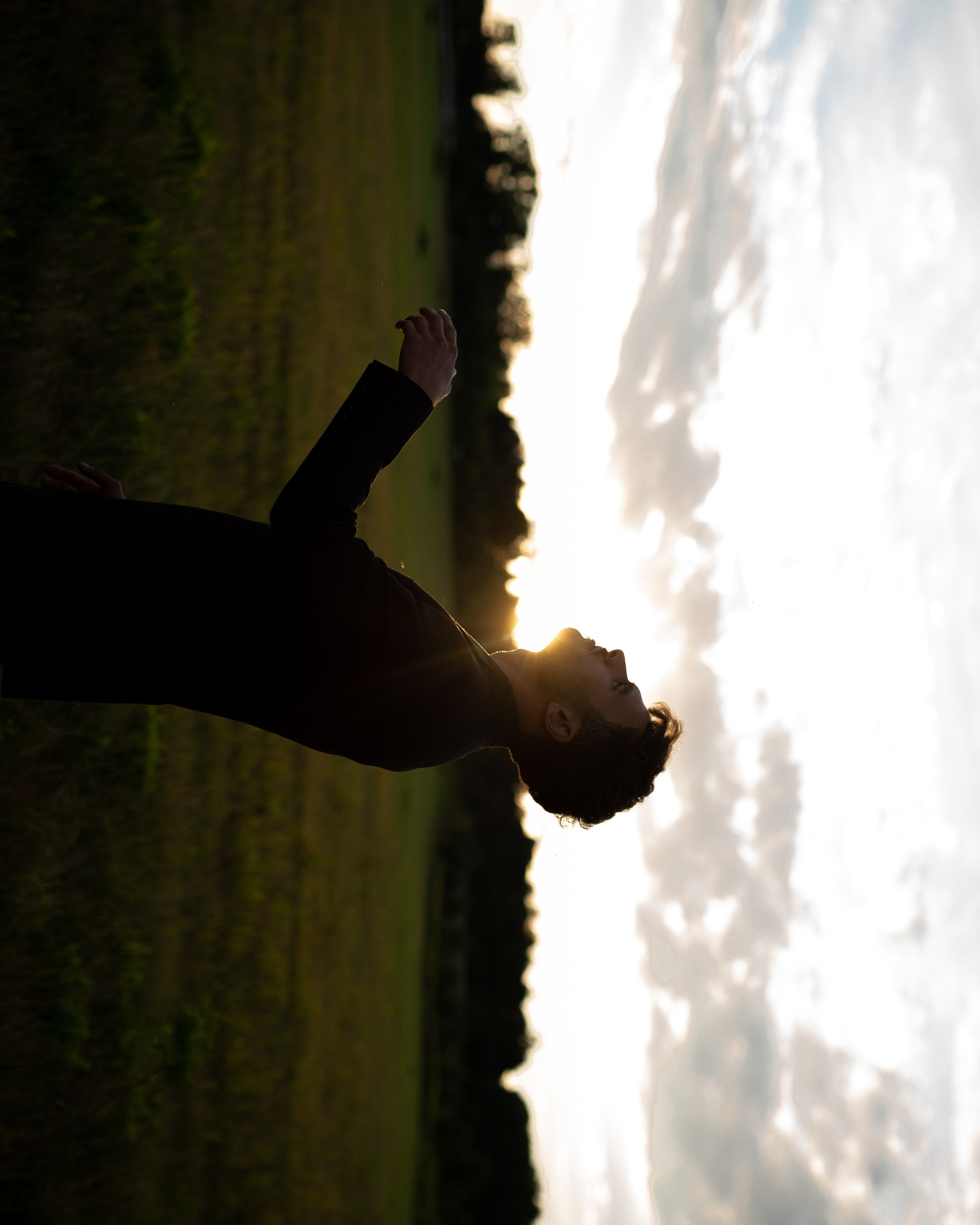 Портрет мужчины на фоне солнца в поле 