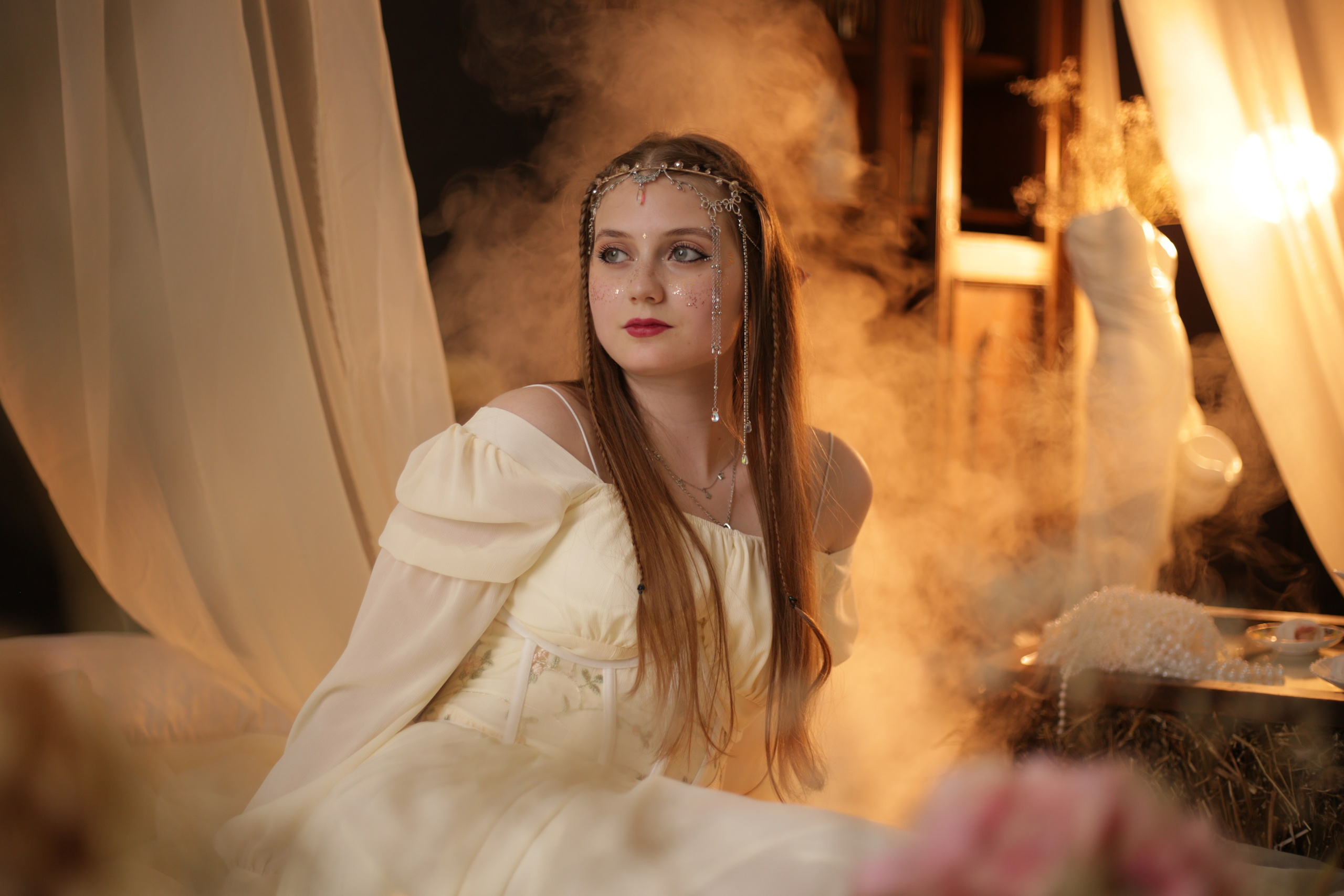 Необычная фотосессия в Перми: девушка в белом платье с ушками и головным убором, сидит на кровати под полупрозрачным балдахином