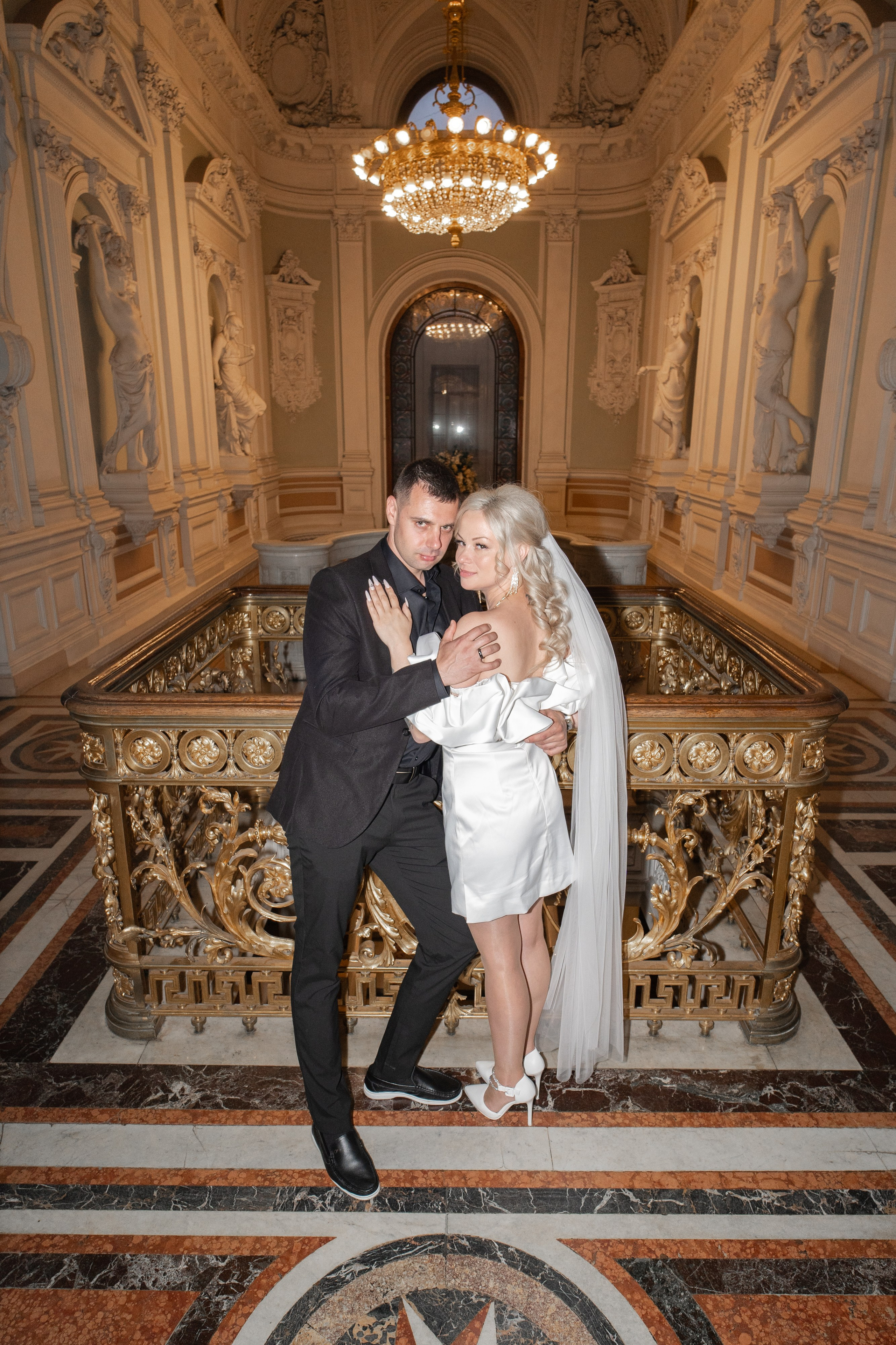 жених и невеста обнимаются на главной лестнице дворца бракосочетания №1 