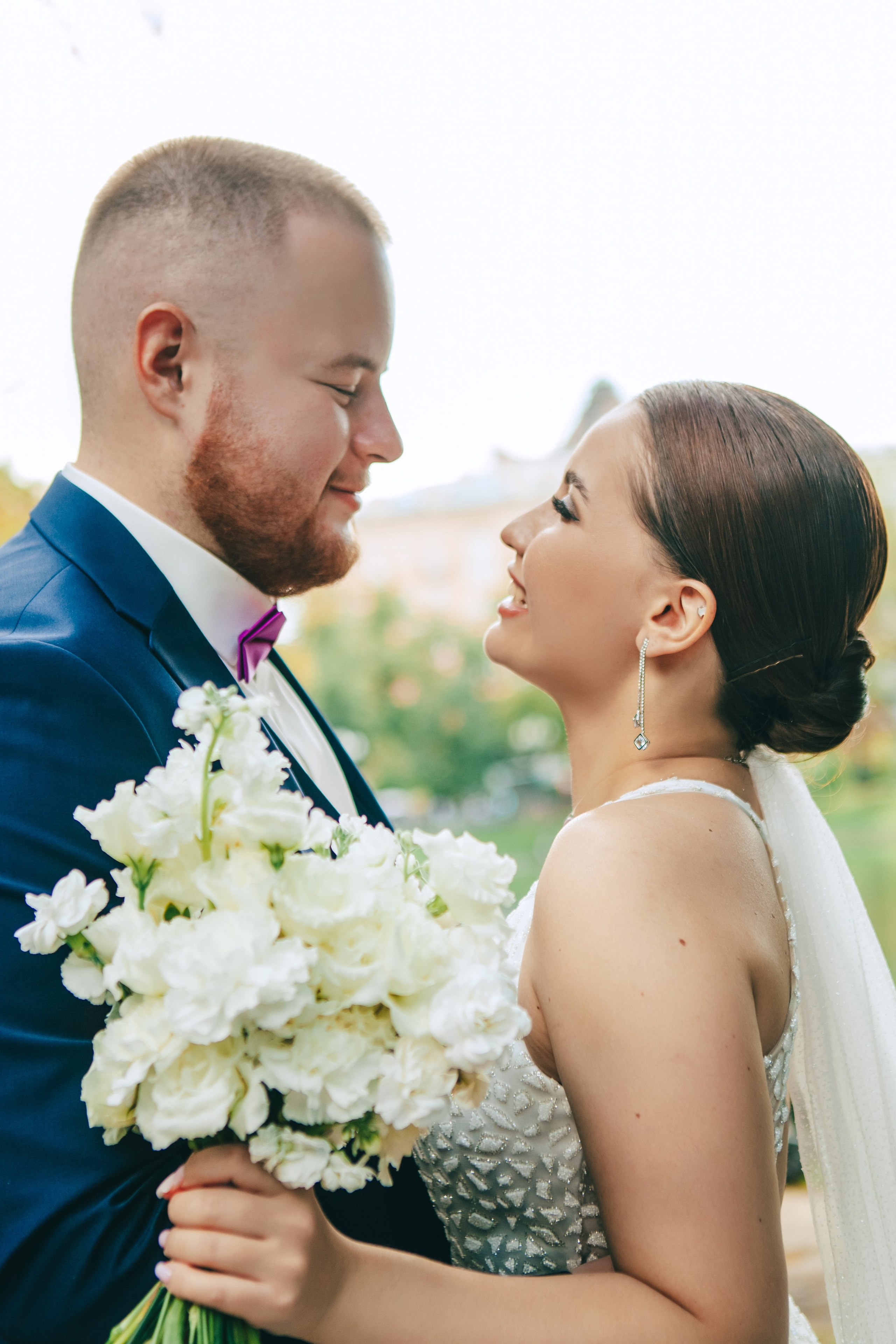 жених смотрит на красивую невесту с букетом цветов