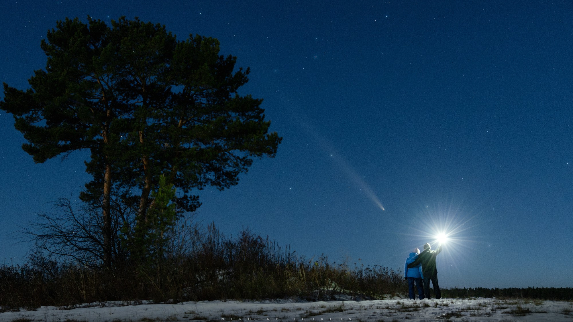 Пара наблюдает за кометой C/2023 A3 (Tsuchinshan-ATLAS) на вечернем небе
