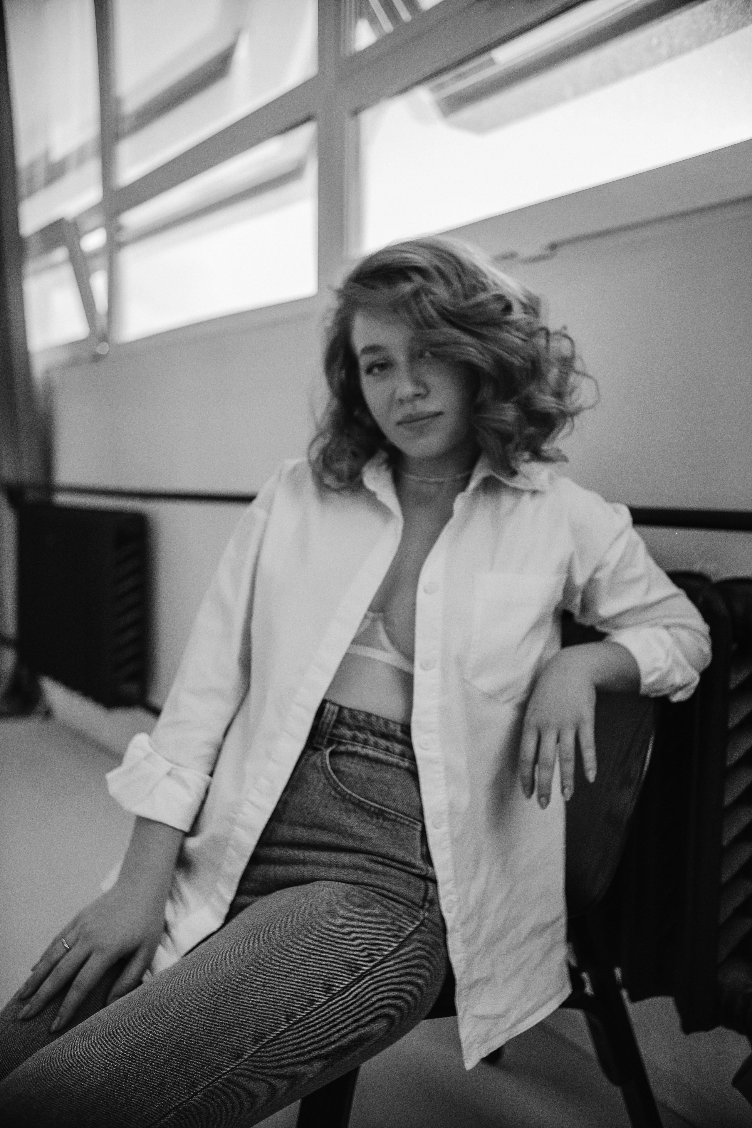 Портретная фотосессия девушка в белой рубашке и джинсах в студии