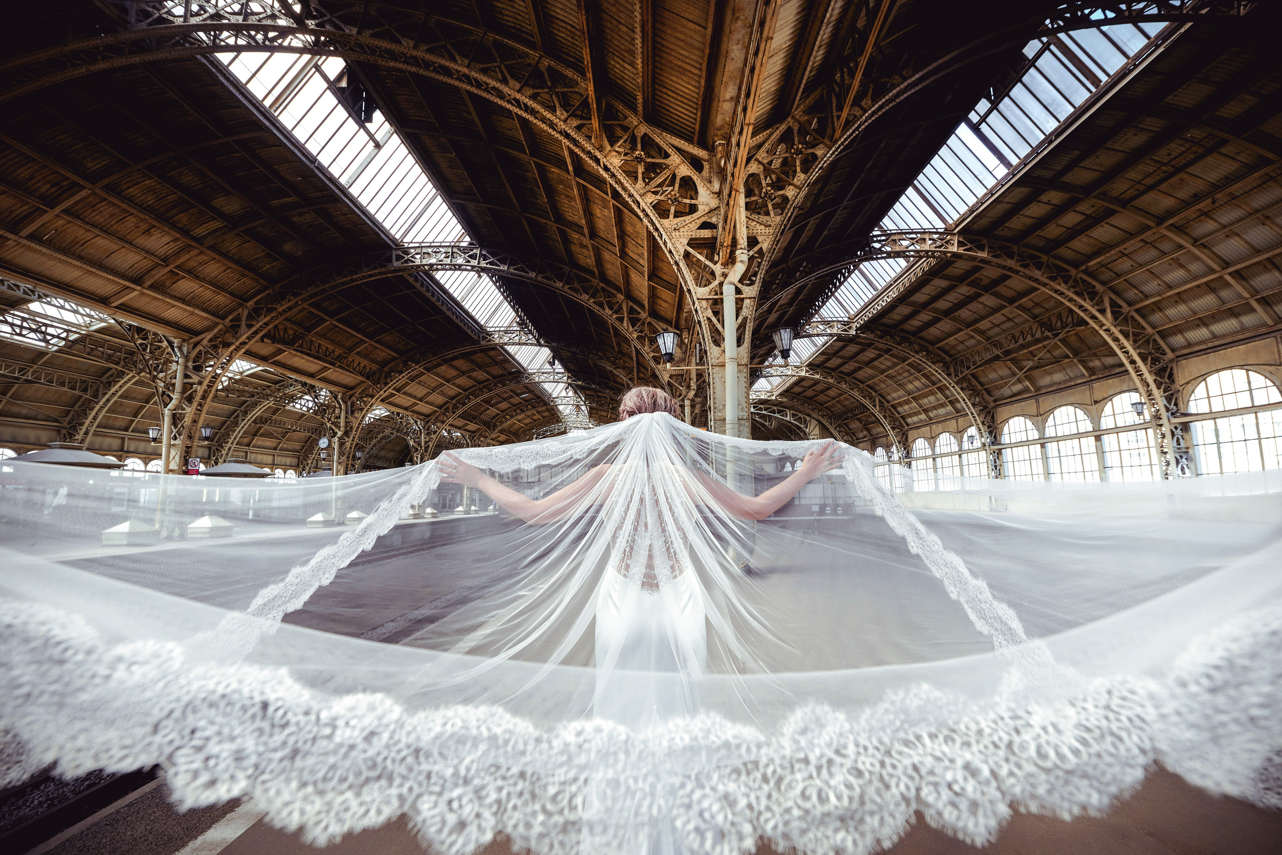 Красивые фотографии со свадьбы на Витебском вокзале, где во время дождя на свадебной прогулке можно фотографироваться под крышей даже с длинной фатой.