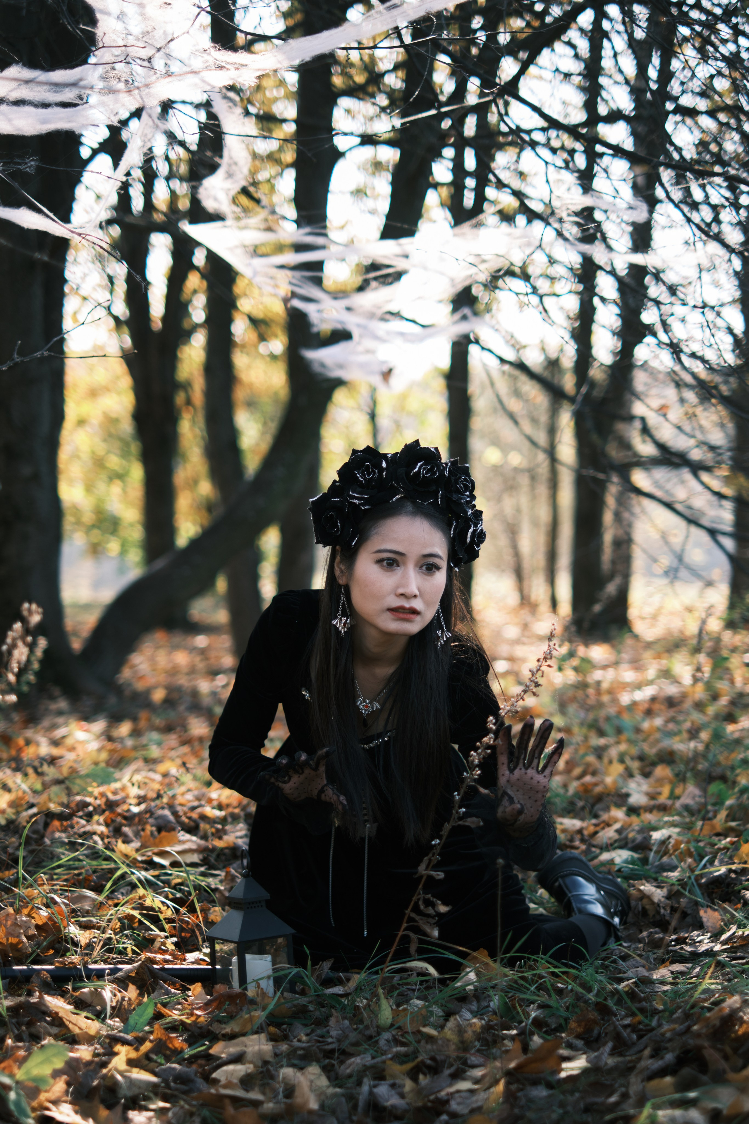 Девушка в готическом костюме пробирается сквозь паутину