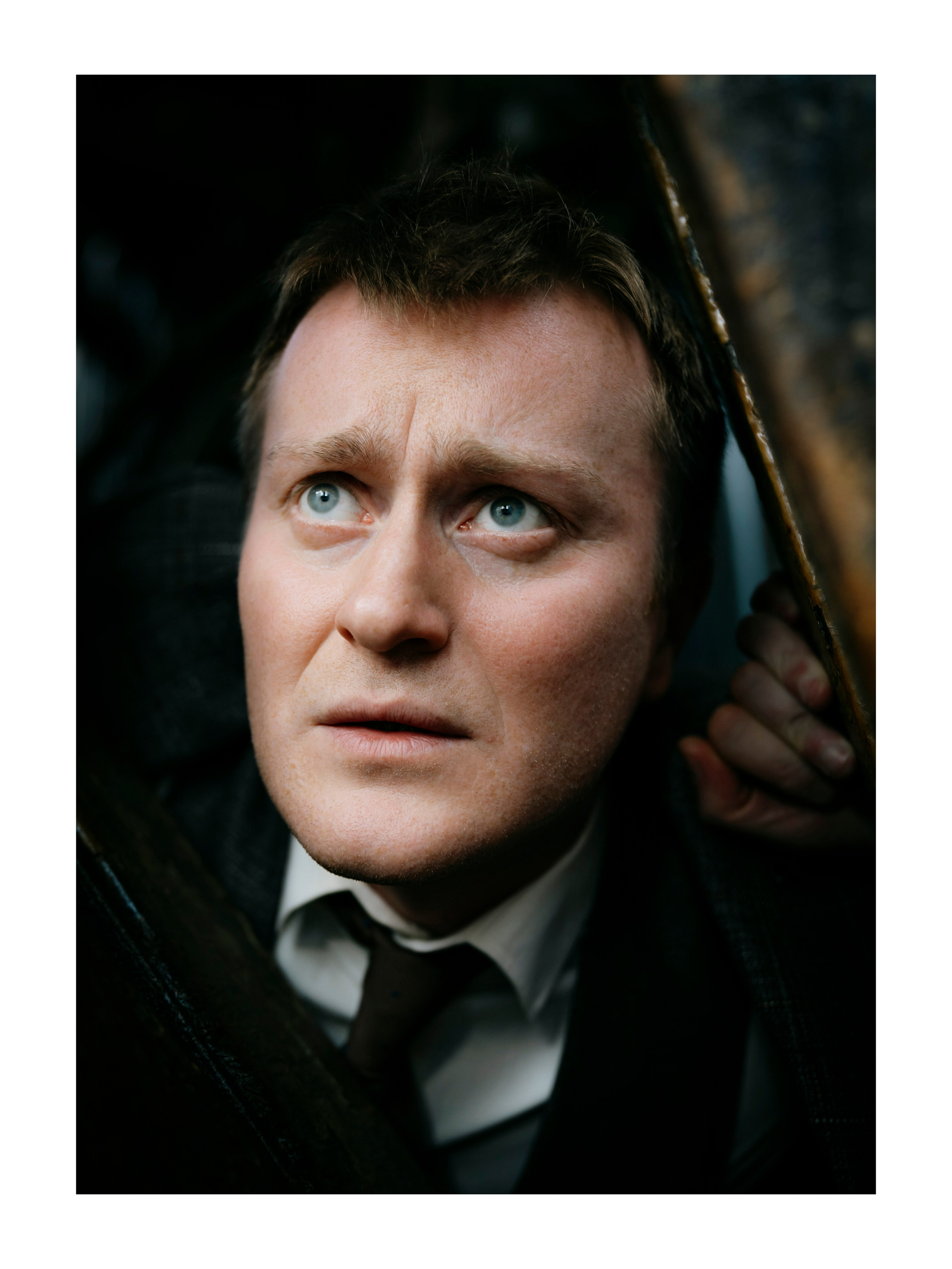 крупный портрет мужчины с голубыми глазами, мужчина смотрит вверх