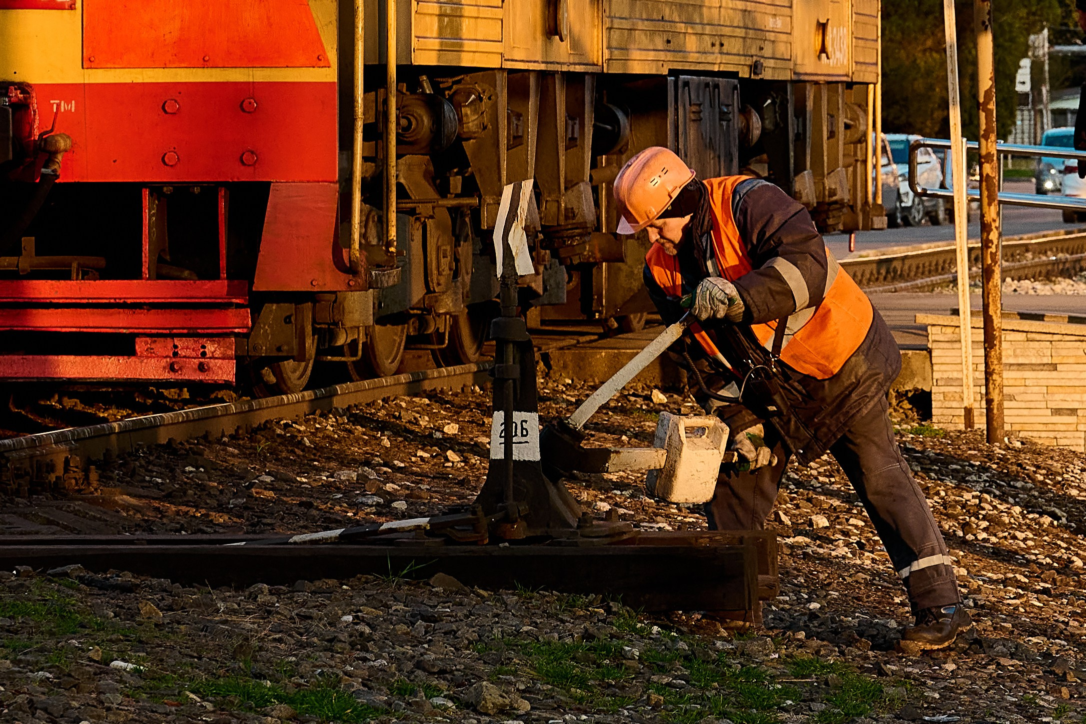 В центре Туапсе, на набережной работник РЖД переключает стрелки на железной дороге 
