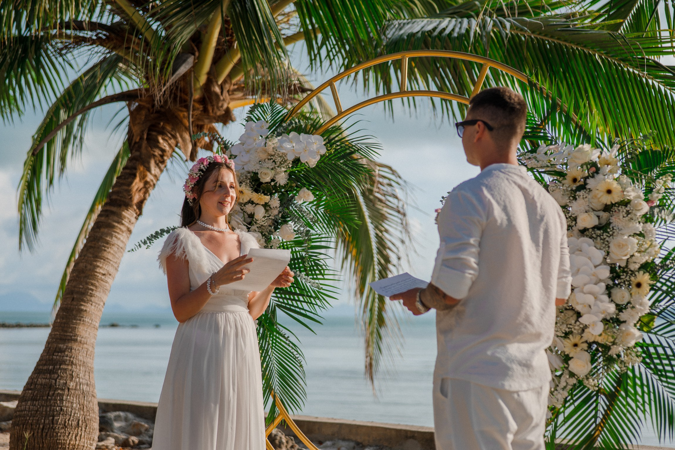 Bride and groom exchanging vows on a private sunset beach