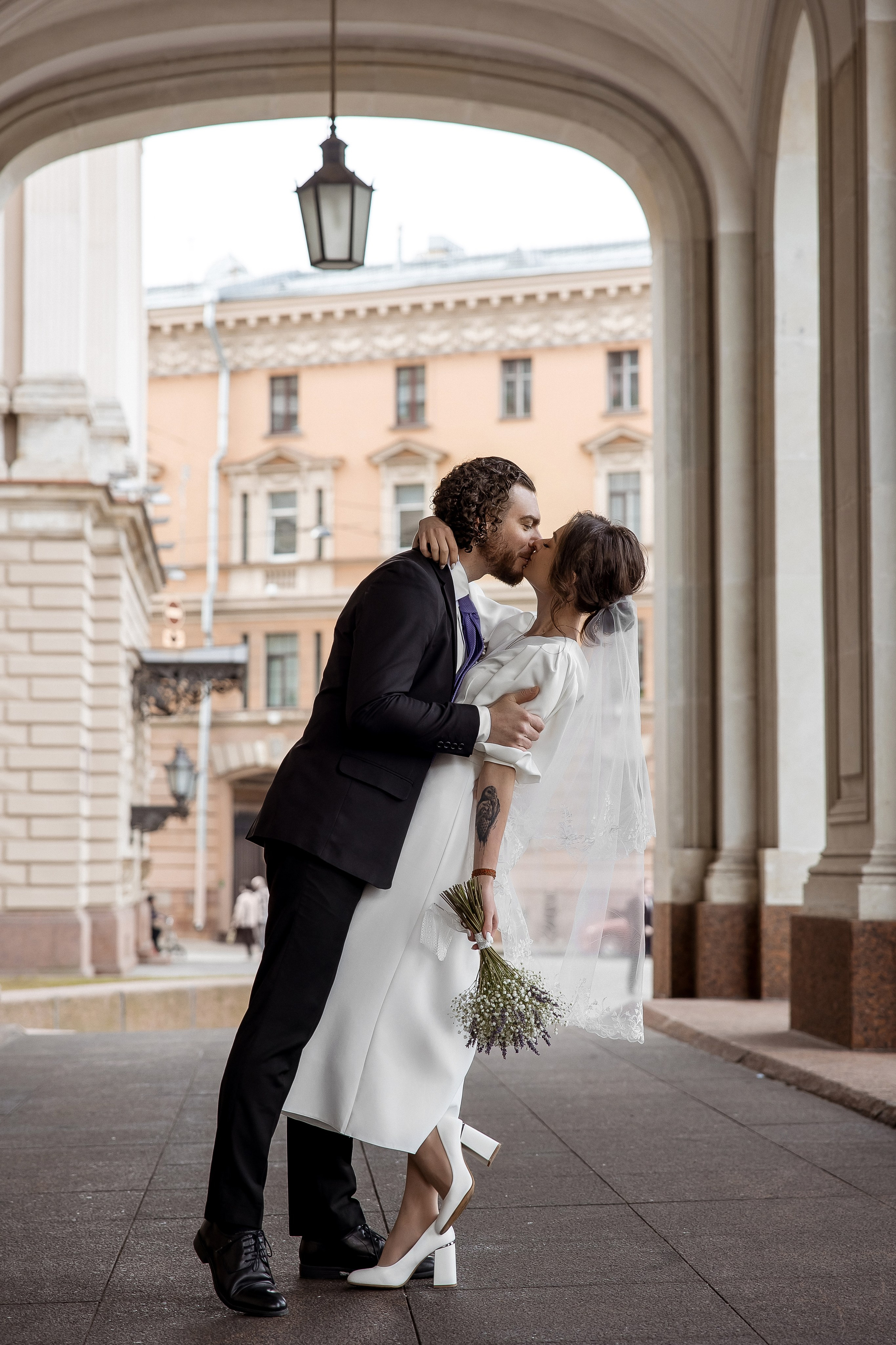 Романтическая свадебная фотосессия - поцелуй на фоне здания Законодательного Собрания Петербурга