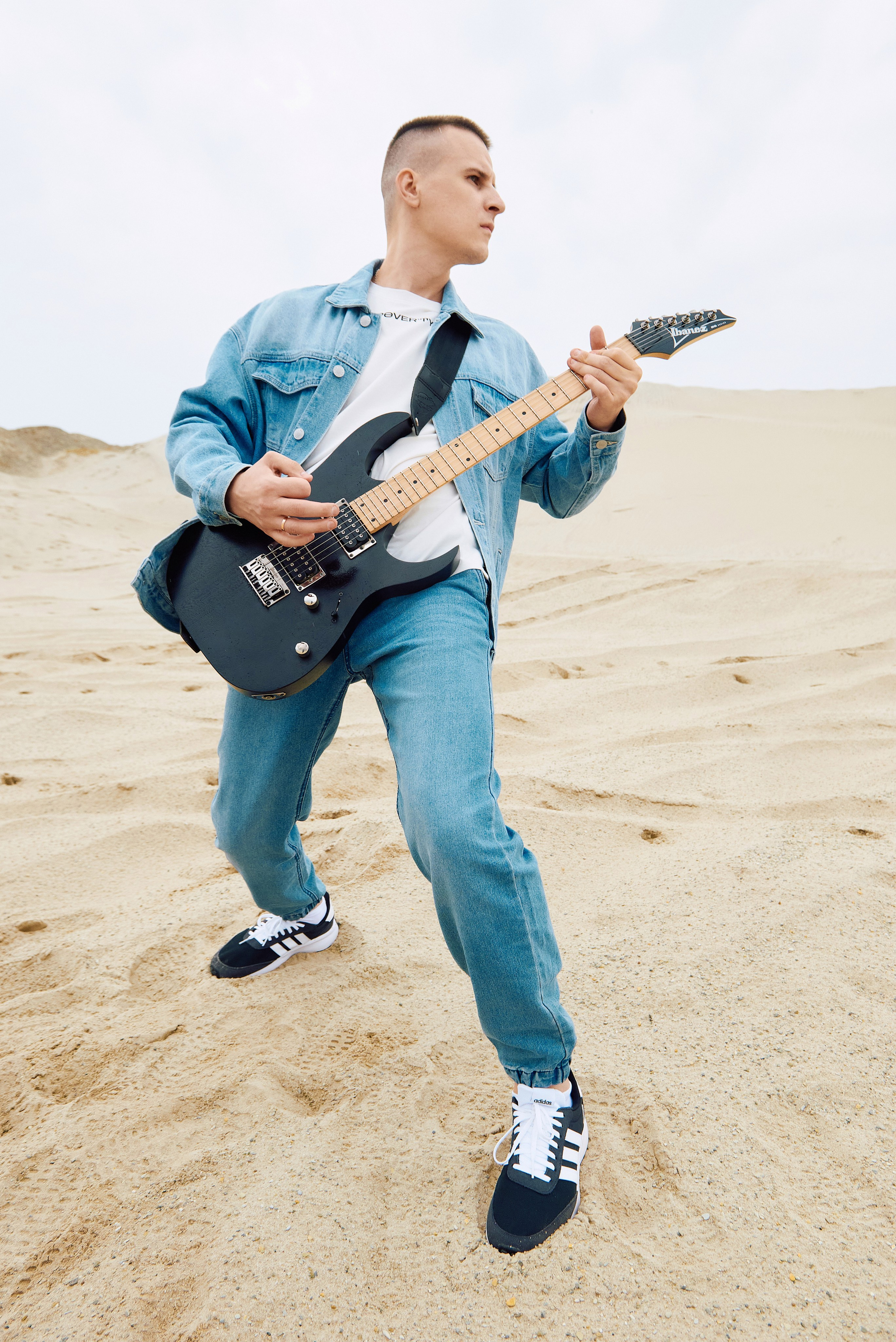 Парень играет на гитаре в пустыне