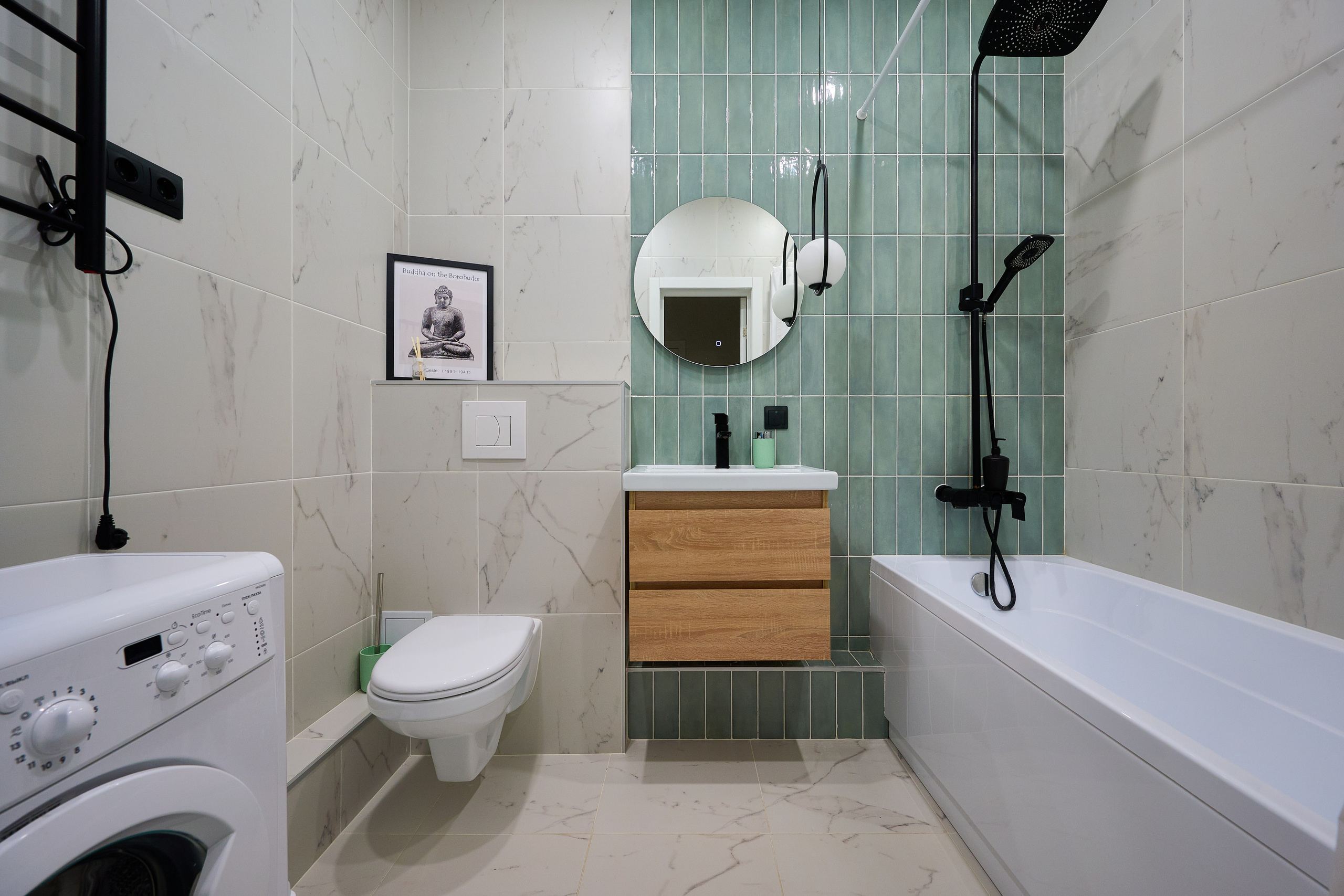 ванная комната с бирюзовой стеной круглое зеркало белая ванна  белые плитки 