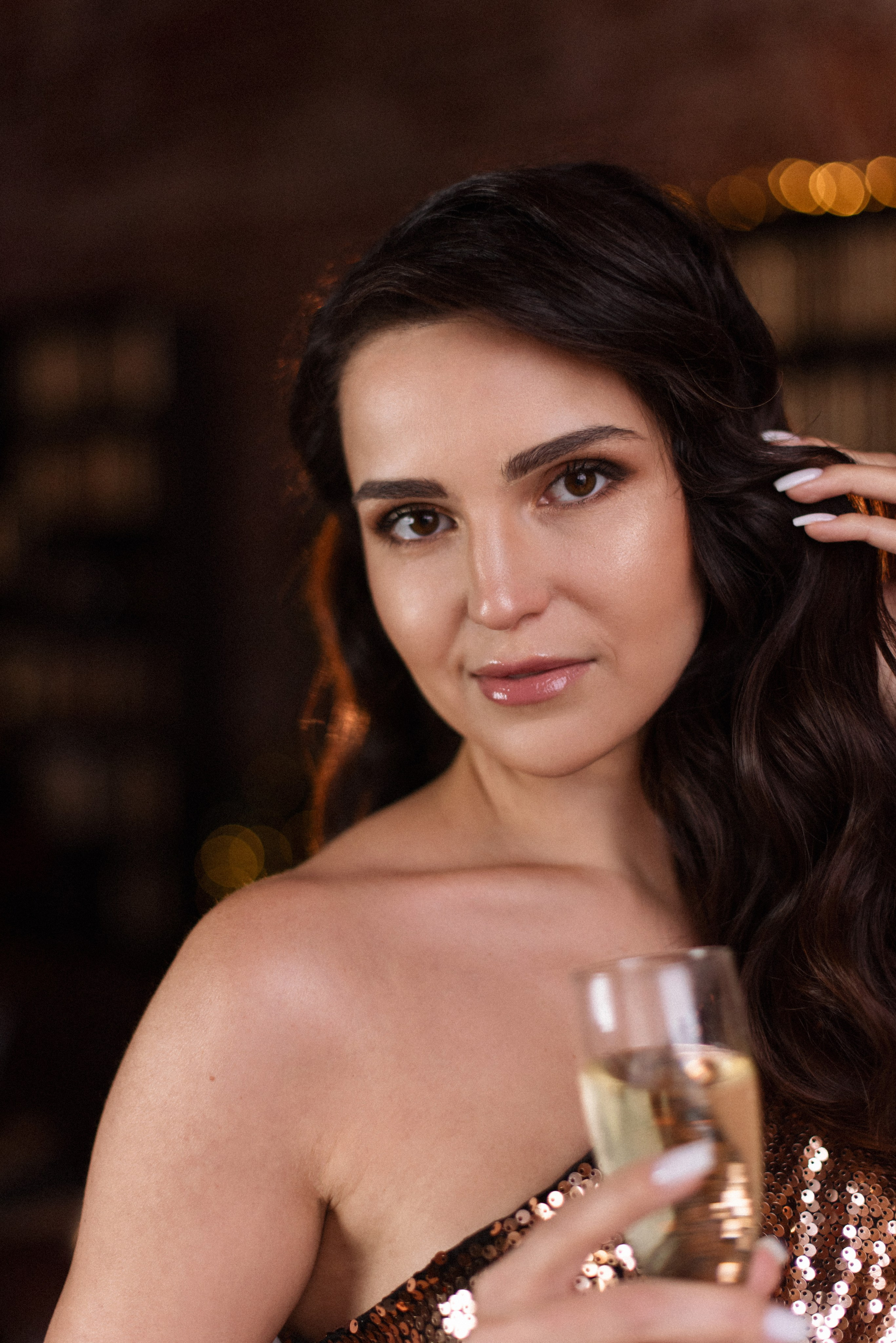 Портрет в новогоднем лофте: девушка в бронзовом платье с лёгким поворотом головы.