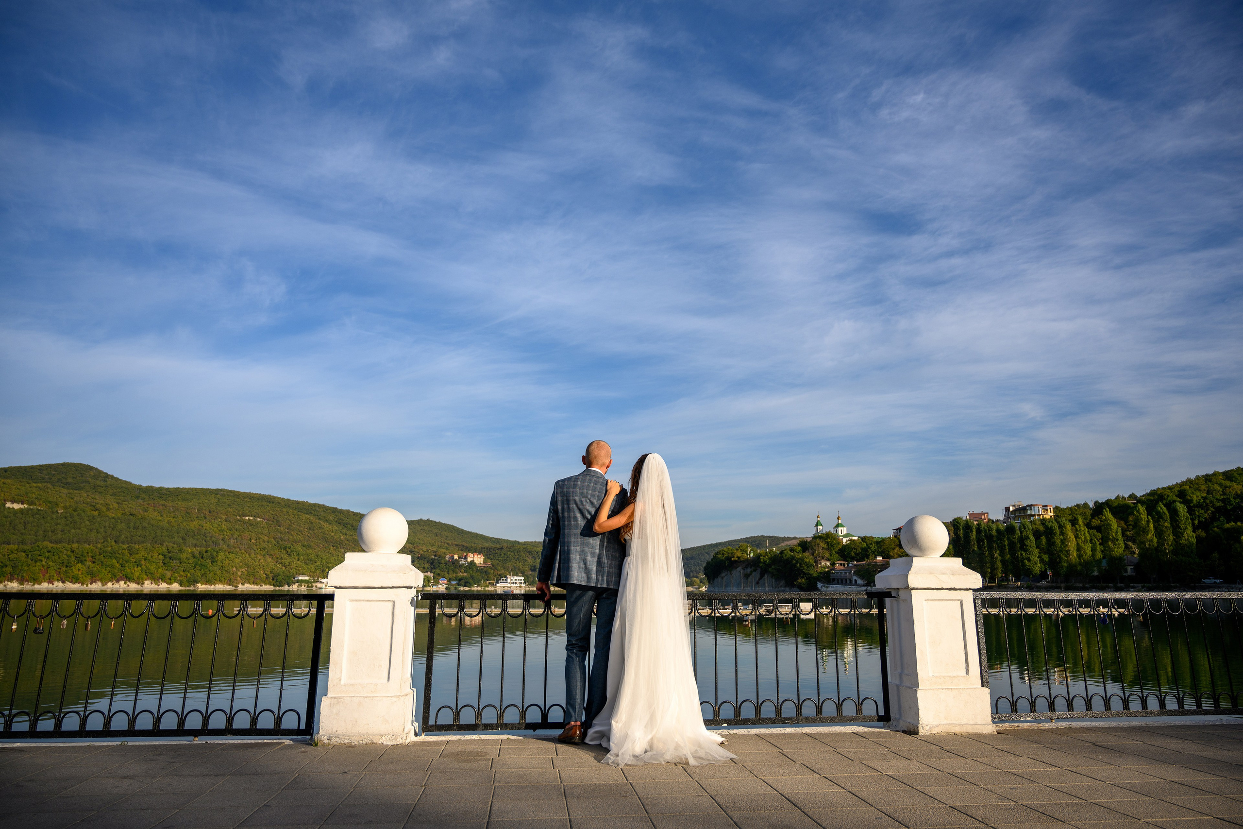 Влюбленная пара стоит на берегу озера.