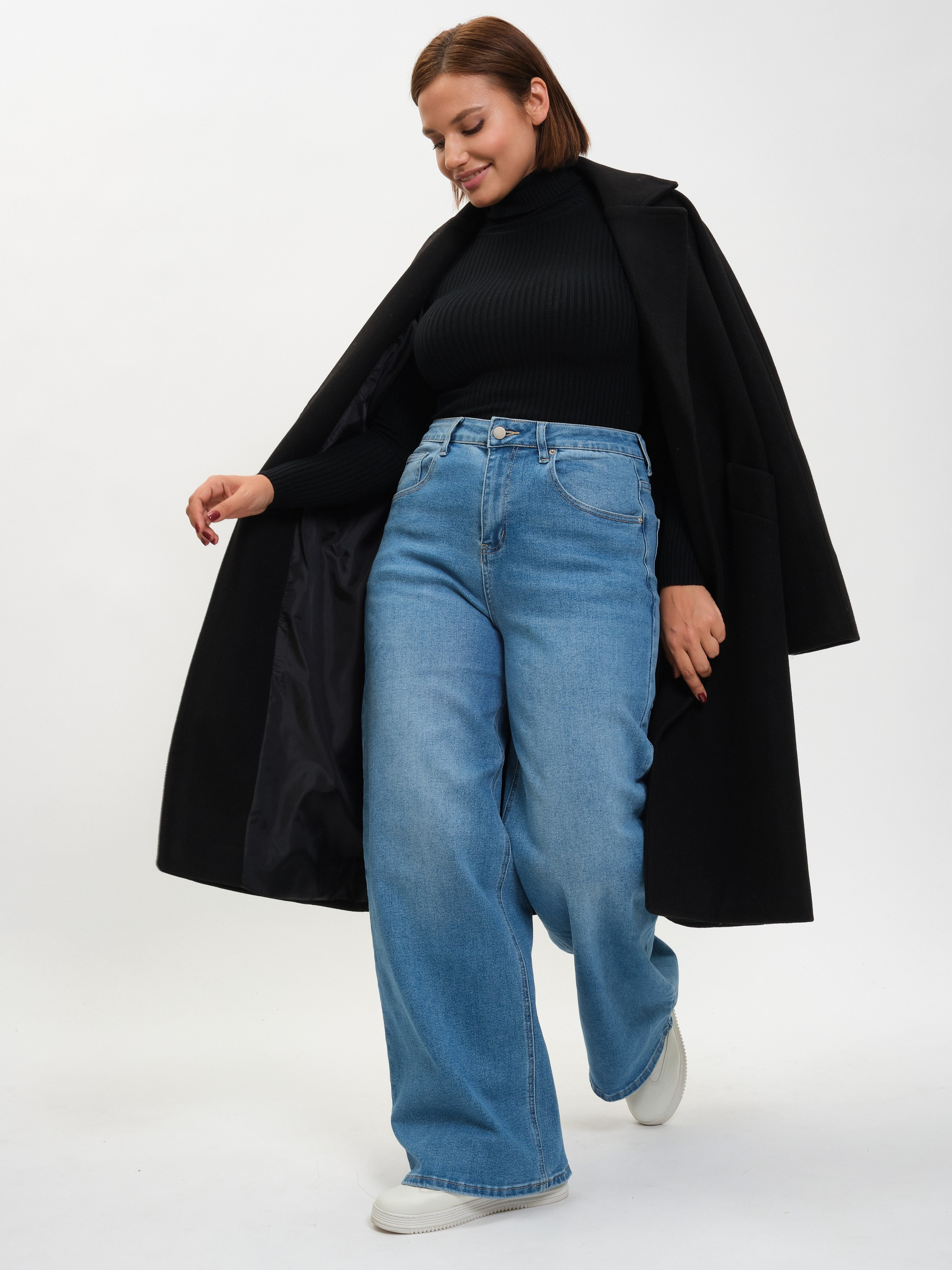 Фотосессия модели в джинсах и чёрном пальто