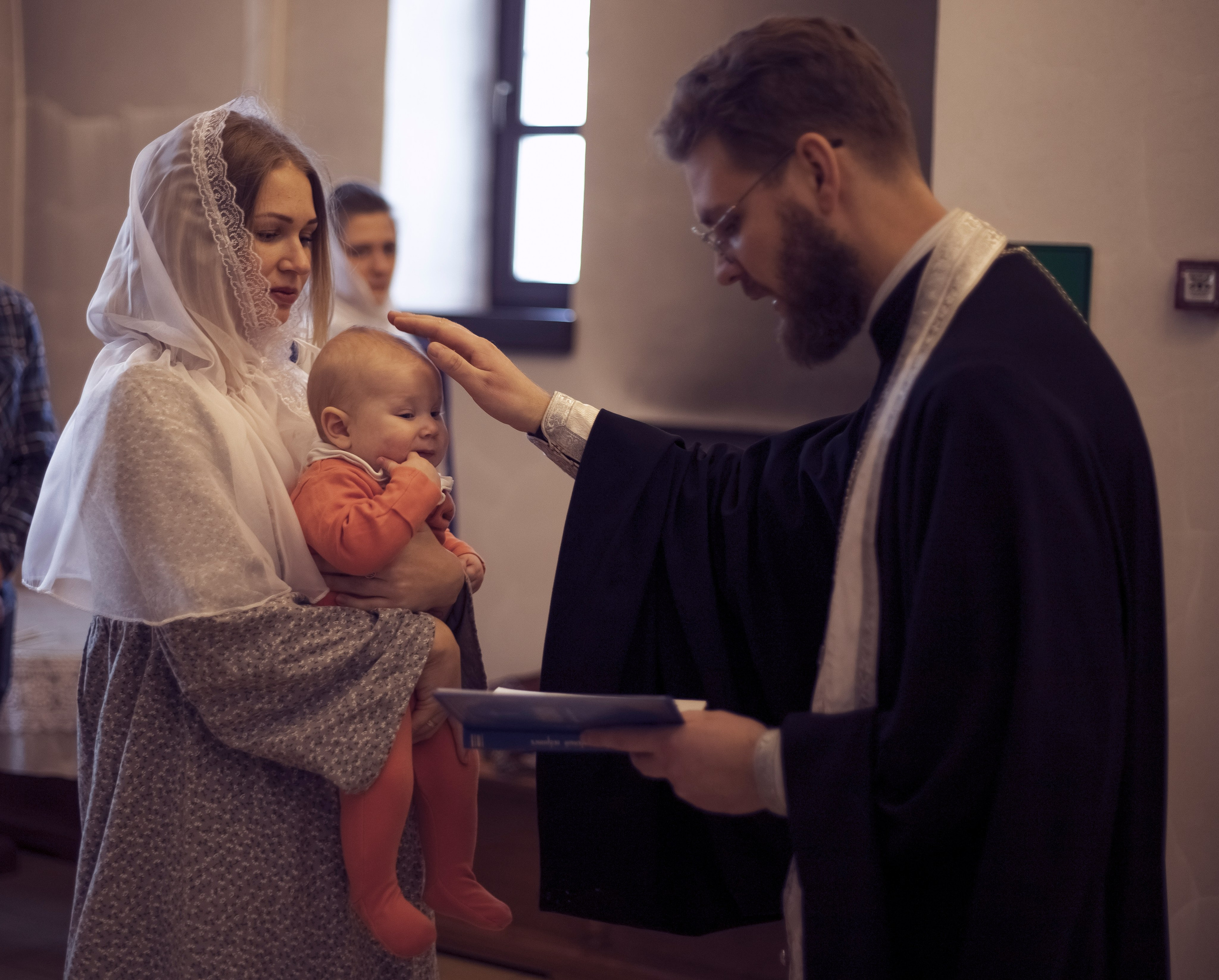 батюшка крестит малыша