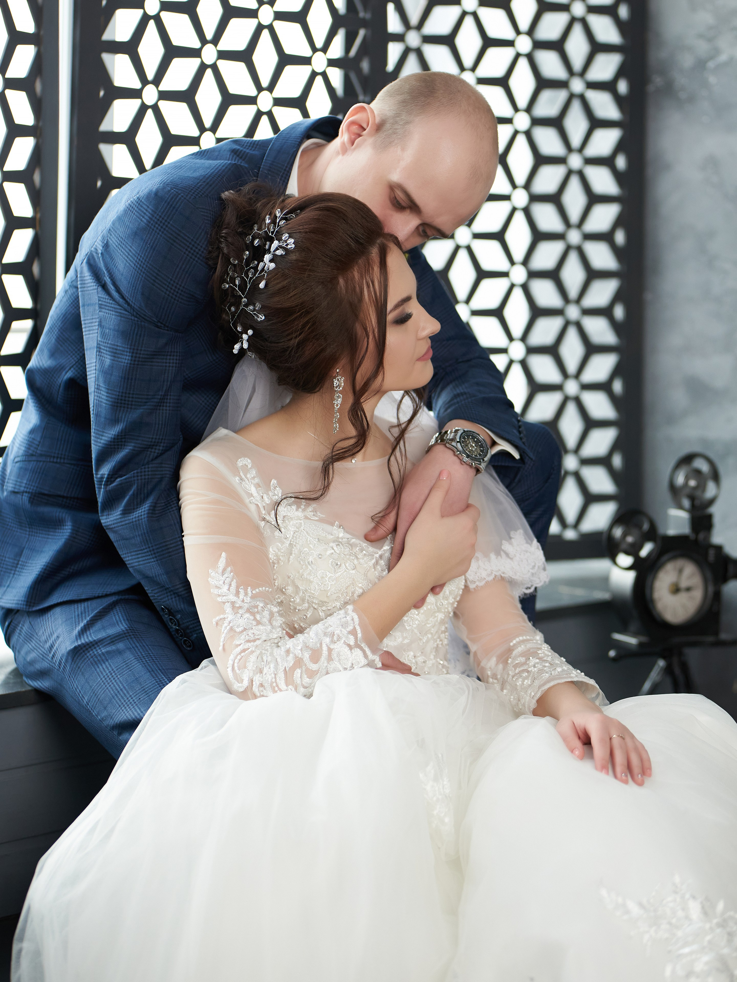 Жених нежно шепчет на ушко невесте слова любви, а фотограф успевает поймать этот момент и запечатлеть его на снимке.