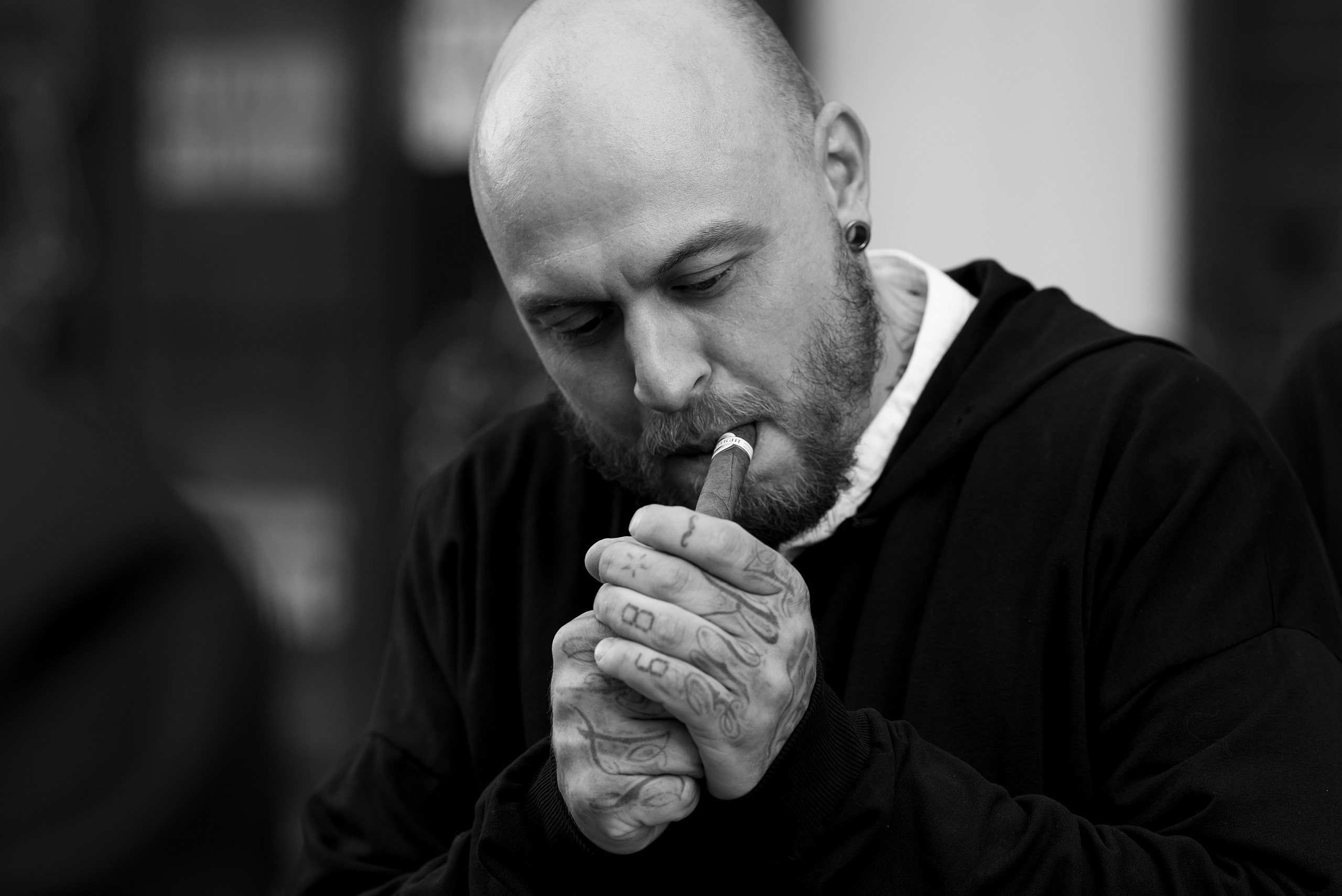 Фотография как человек закуривает сигару.