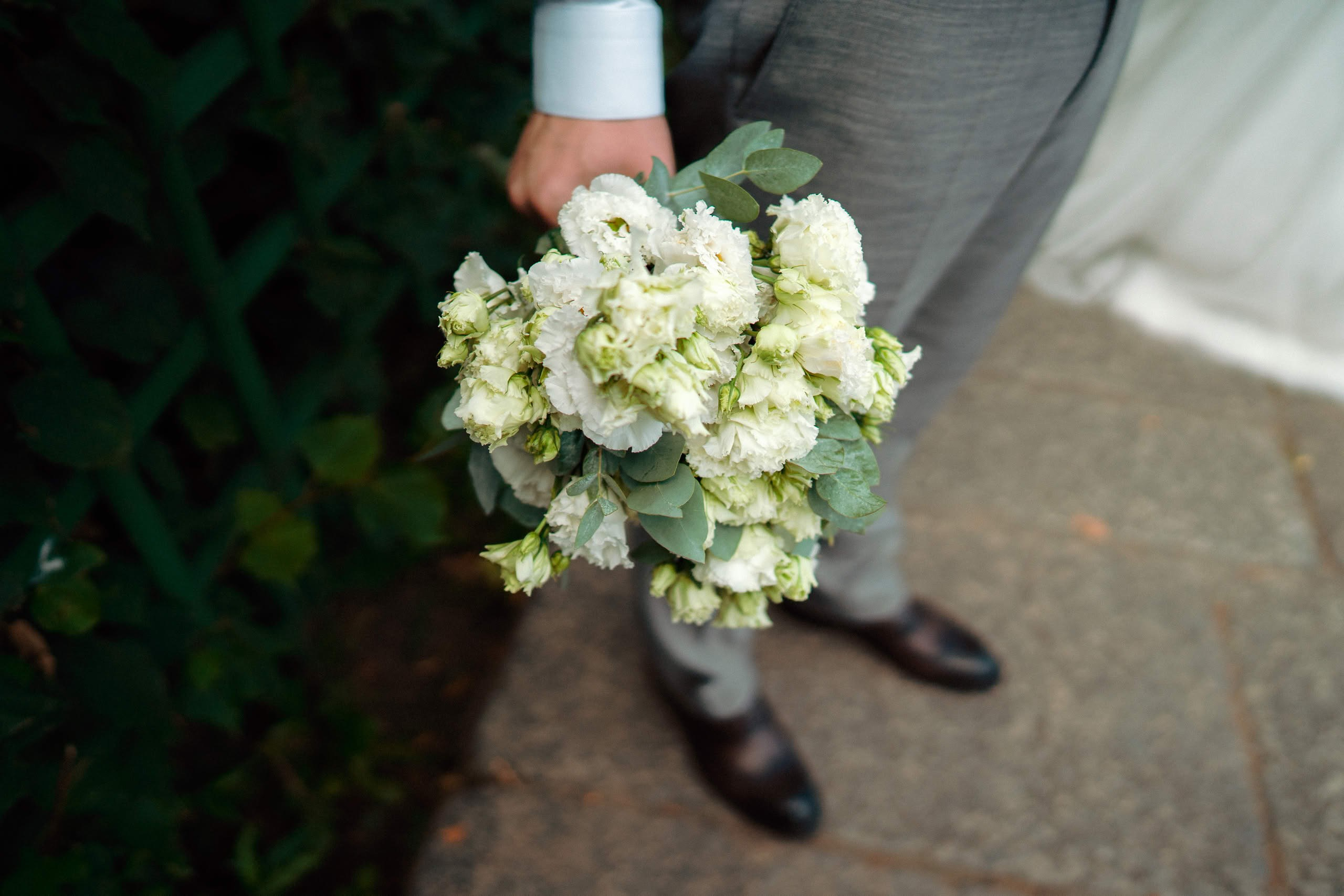 Свадебный букет невесты в руках жениха на прогулке