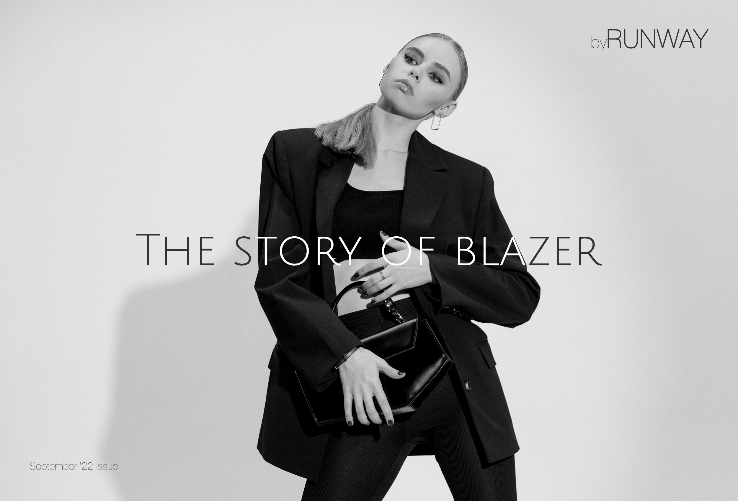 Девушка в чёрном блейзере и держит стильную сумку в руках на белом фоне