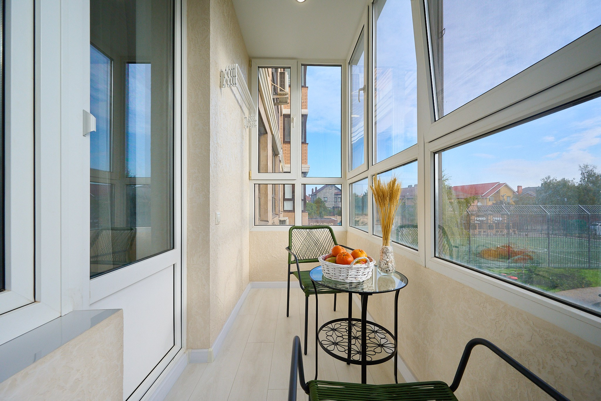 балкон светлые оттенки темный столик и стулья панорамные окна