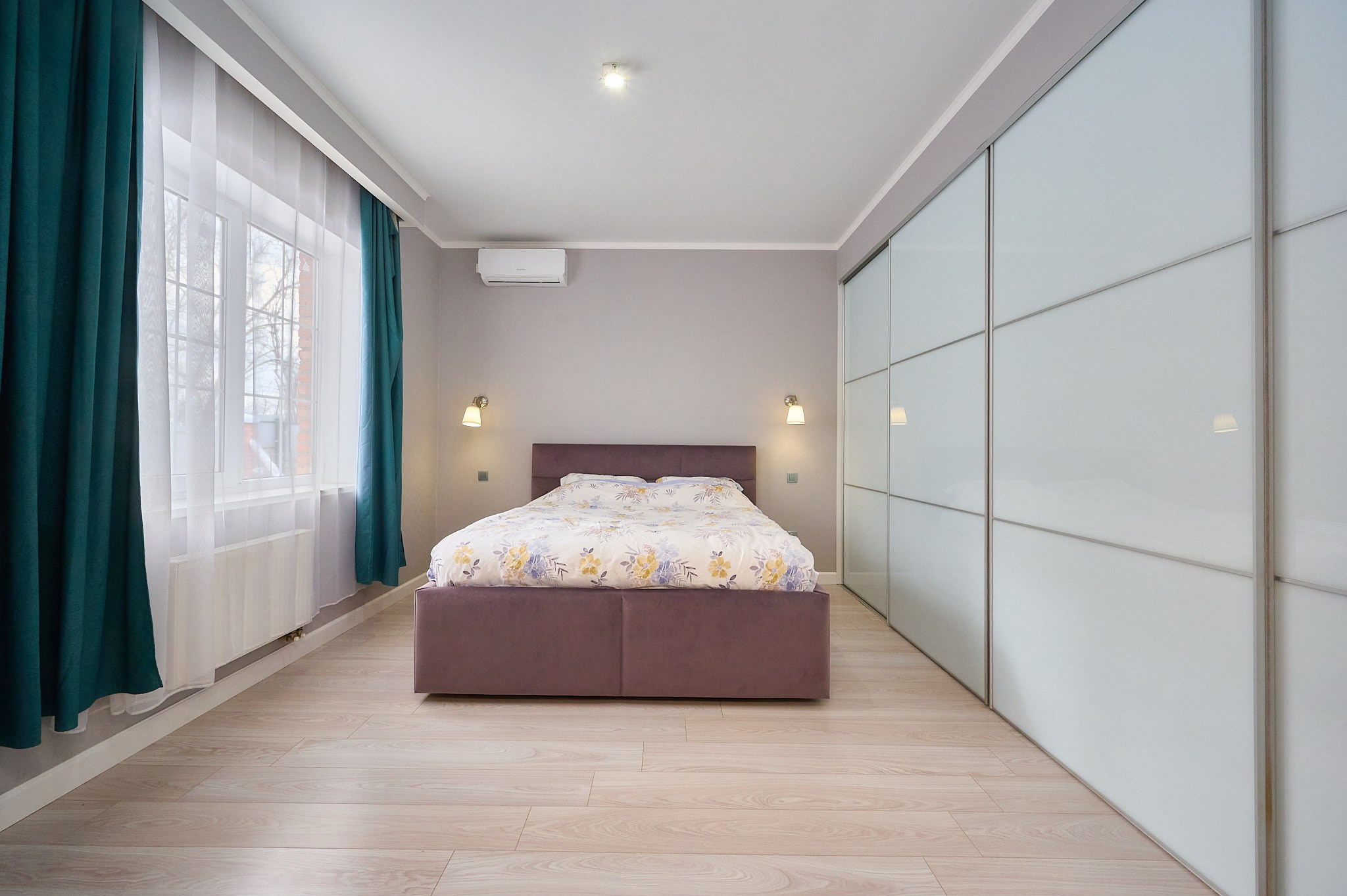 комната фиолетовая кровать  зеленые шторы светлый ламинат 