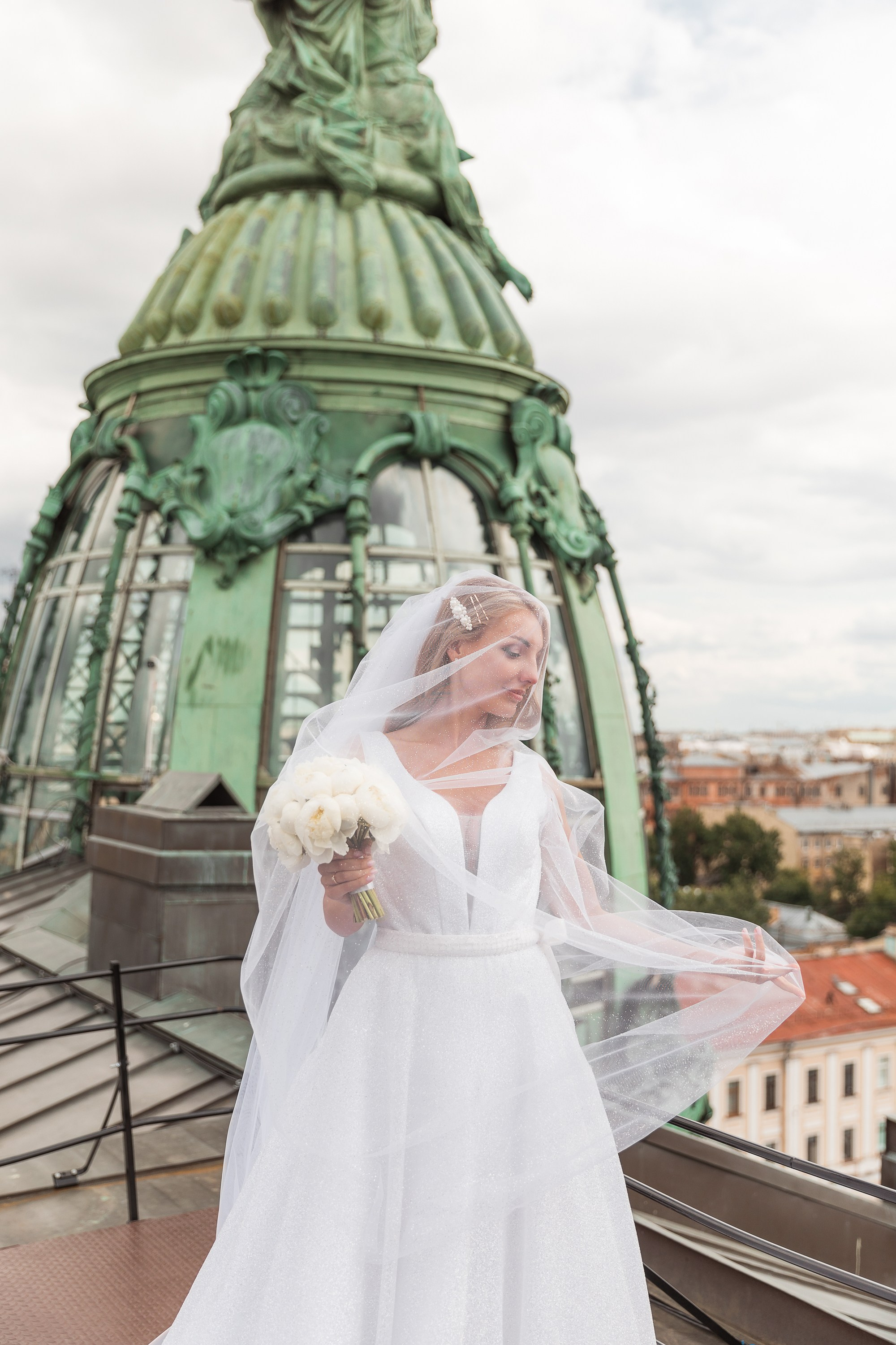 Невеста с фатой и букетом на крыше дома Зингер