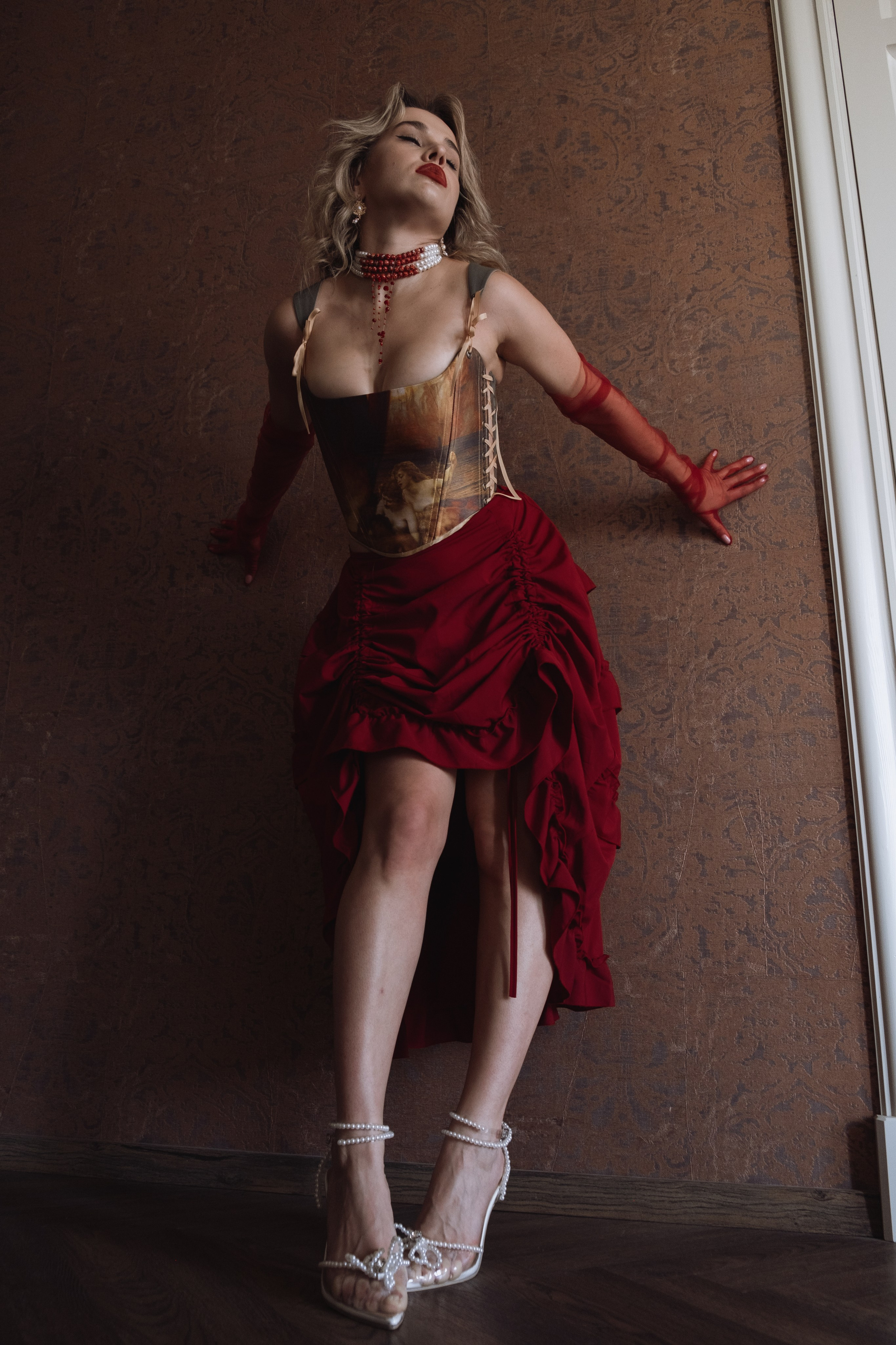 Женщина в театральном образе у коричневой стены