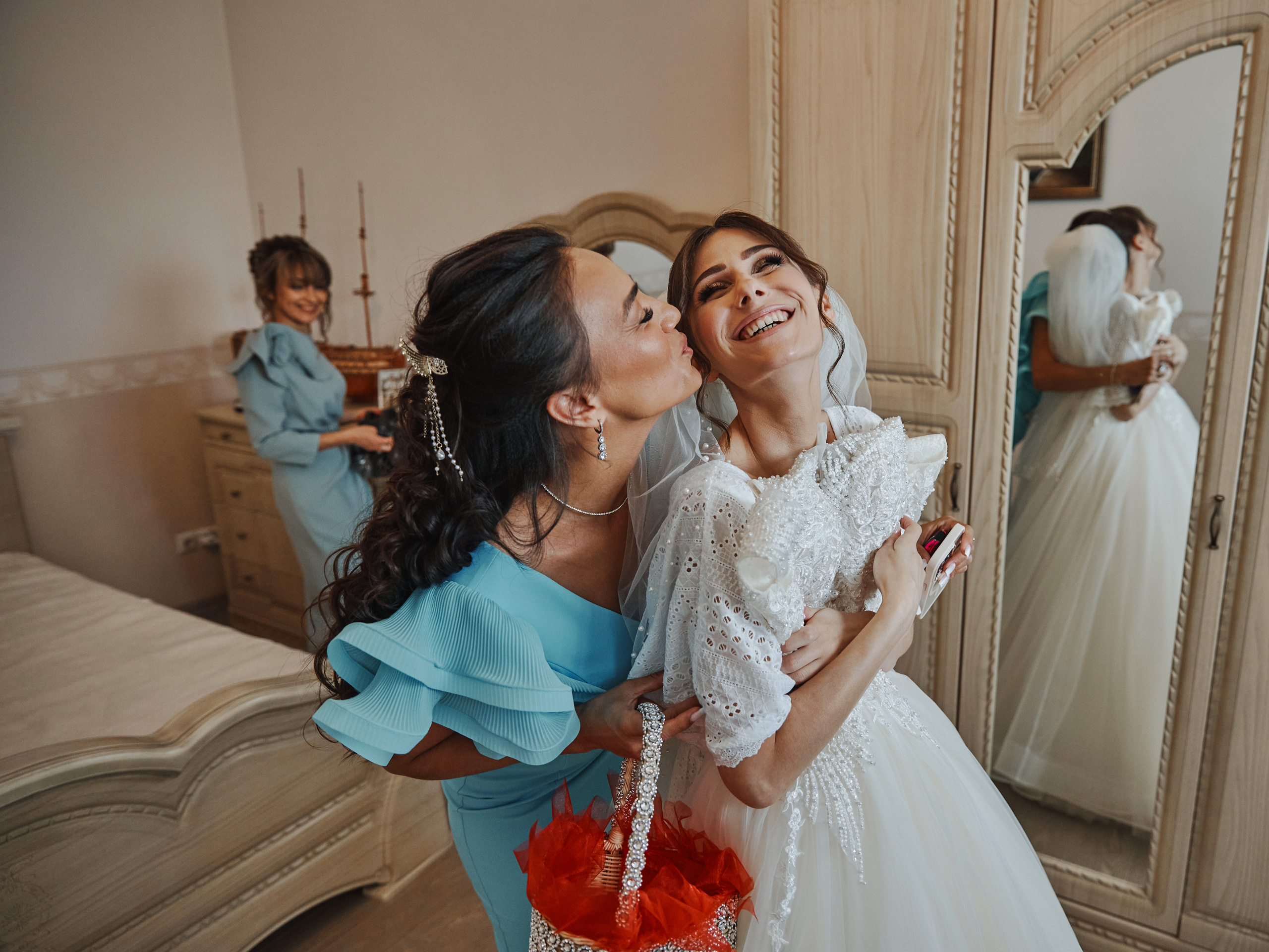 Невеста смеется с подружкой во время сборов