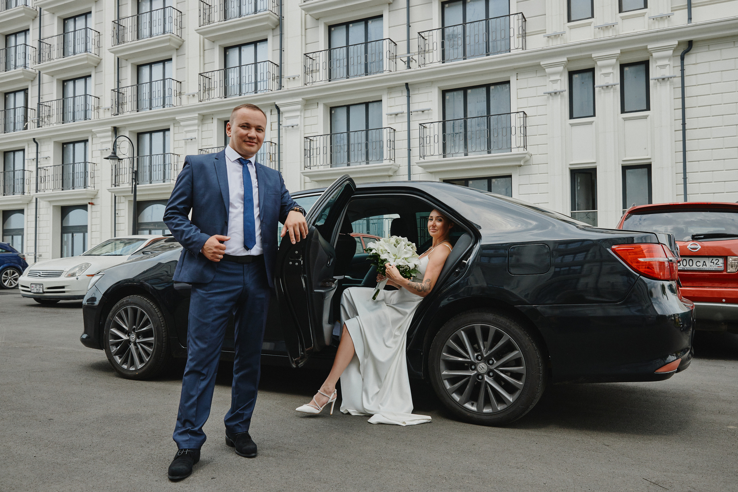 Жених с невестой возле автомобиля