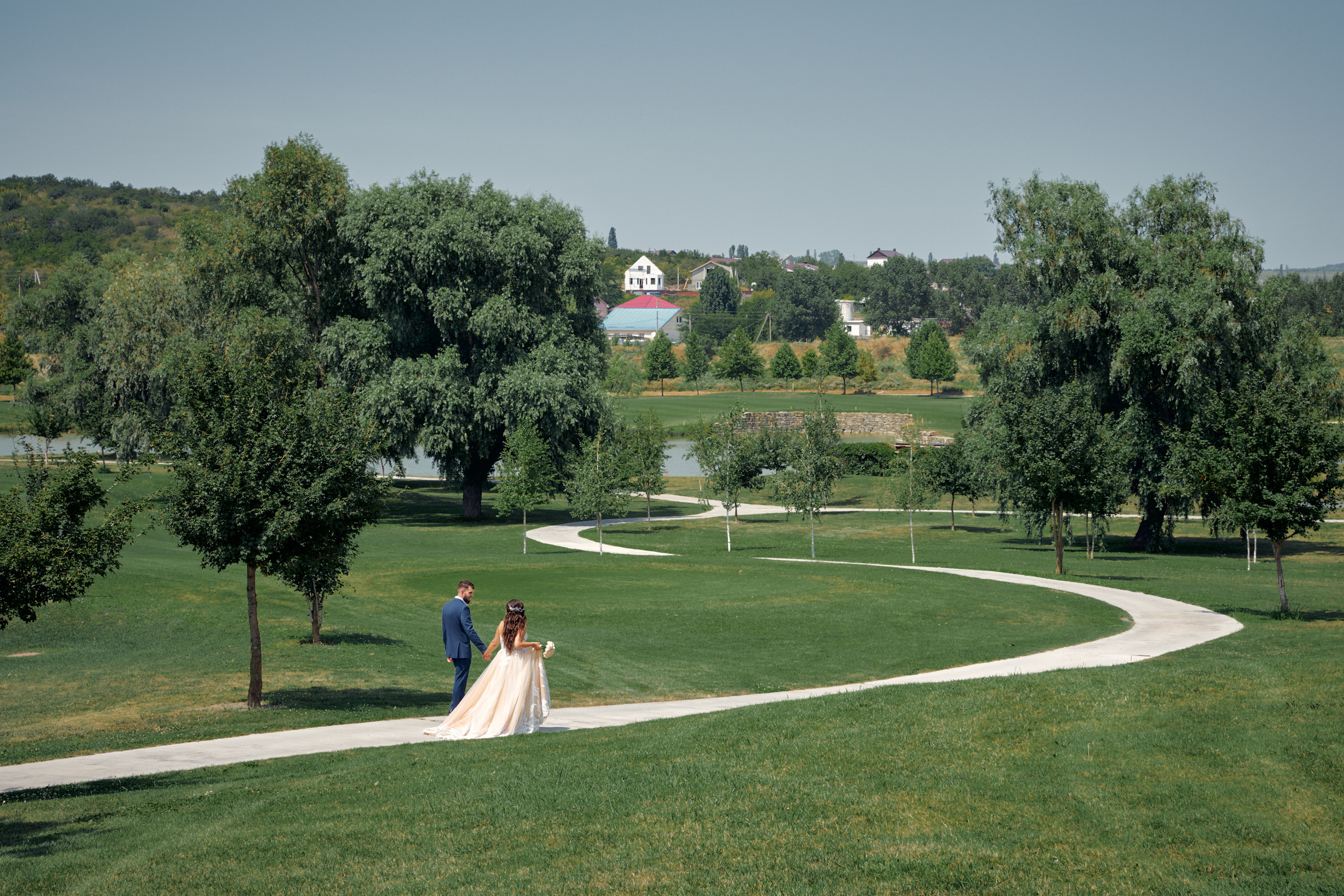 Жених и невеста идут по тропинке вдаль 