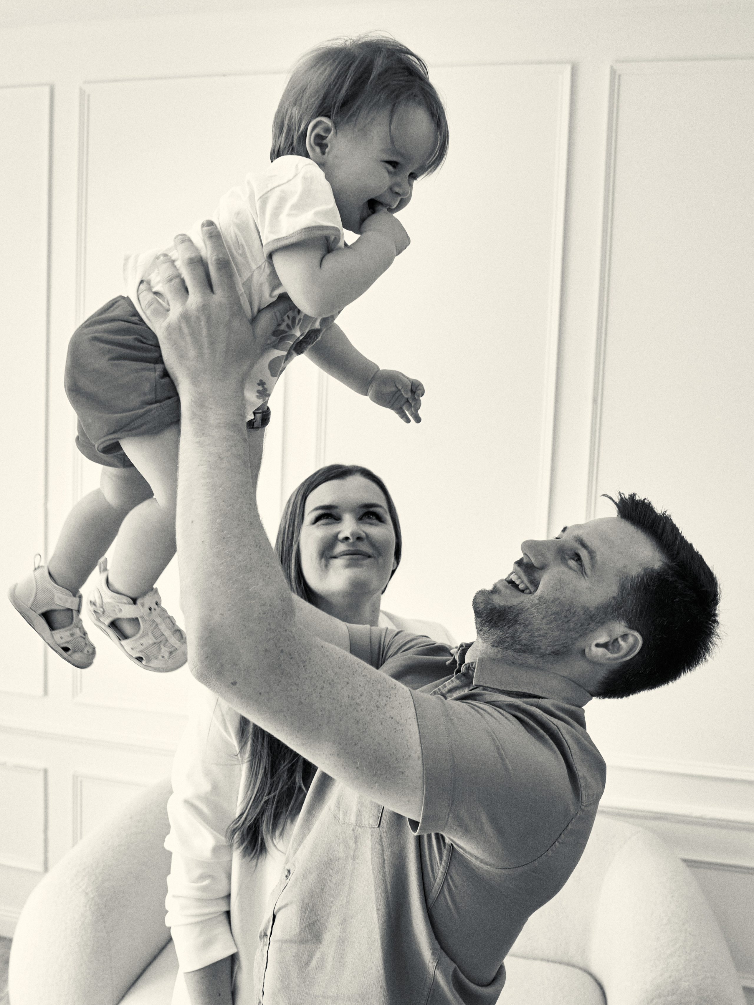 Чб фотография. Отец подбрасывает дочку над собой.