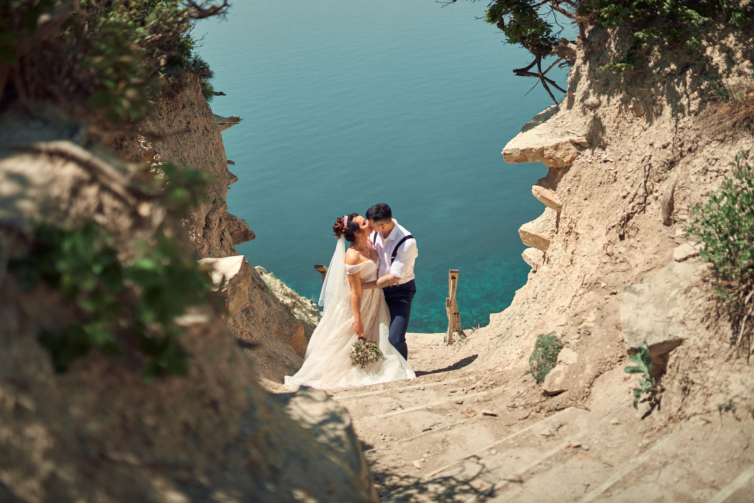 Жених и невеста целуются на фоне моря в Анапе