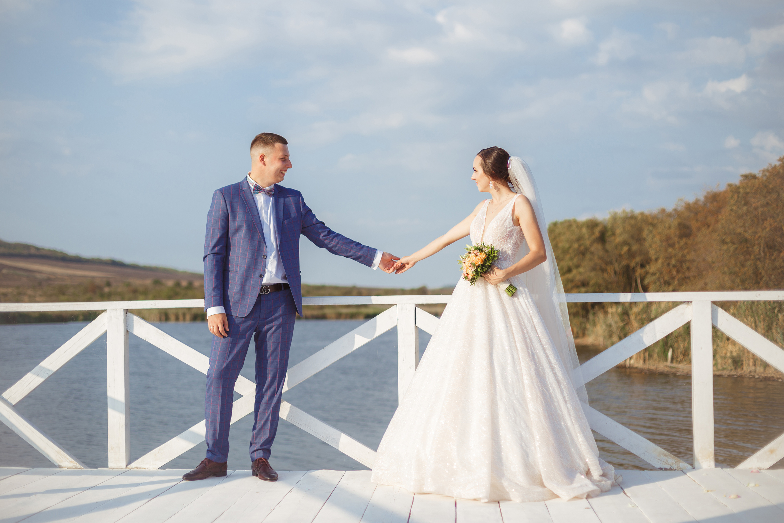 Жених и невеста на причале у озера
