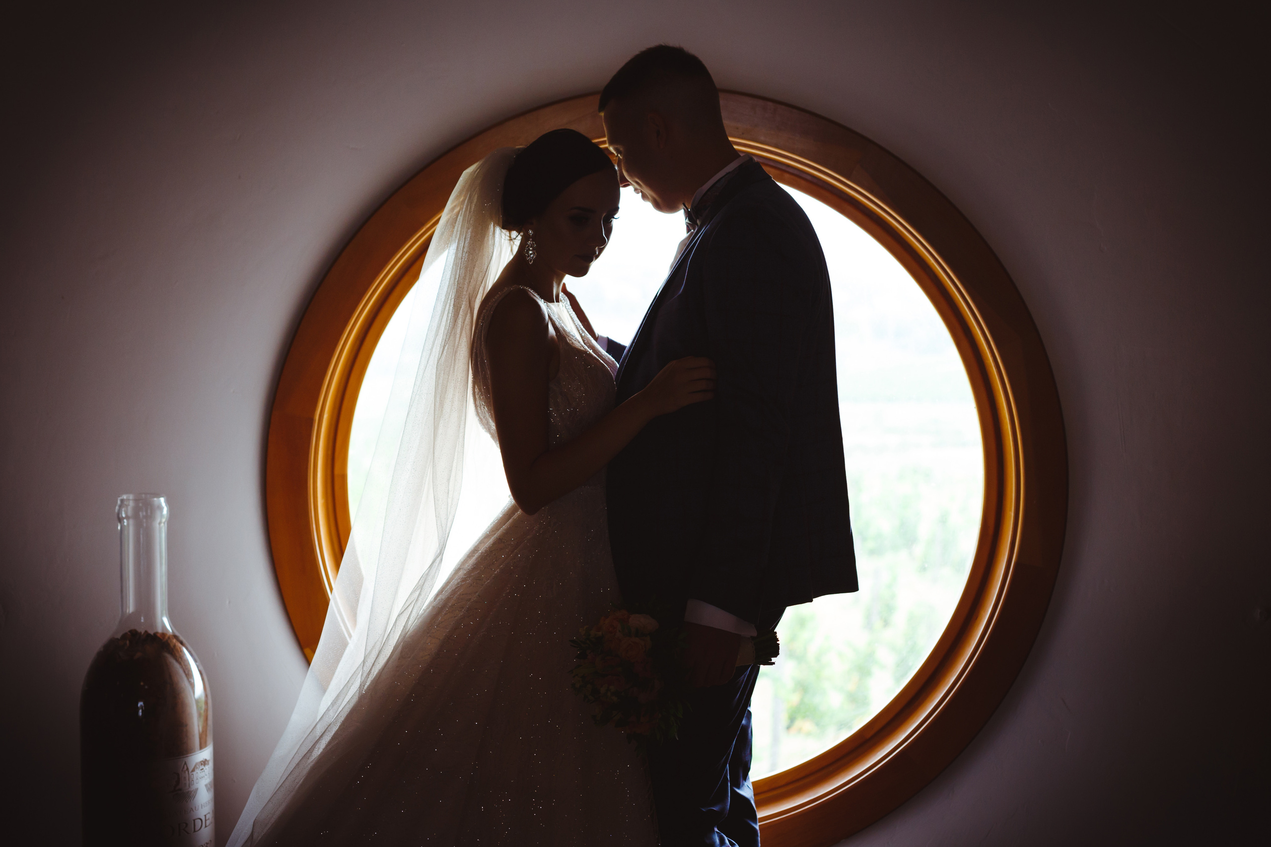 Силуэт молодоженов на фоне круглого окна