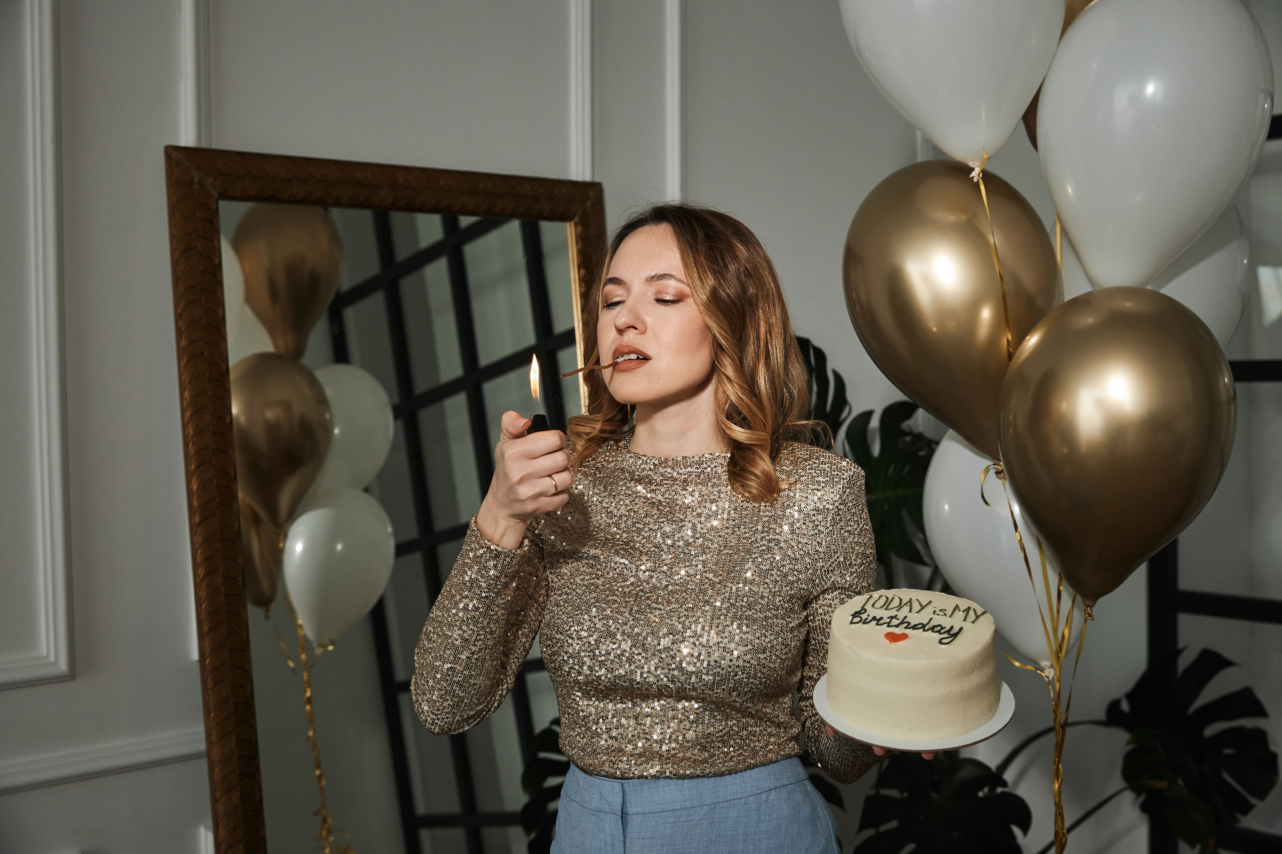 Фото прикуривает свечку на торте в день рождения в студии в Анапе