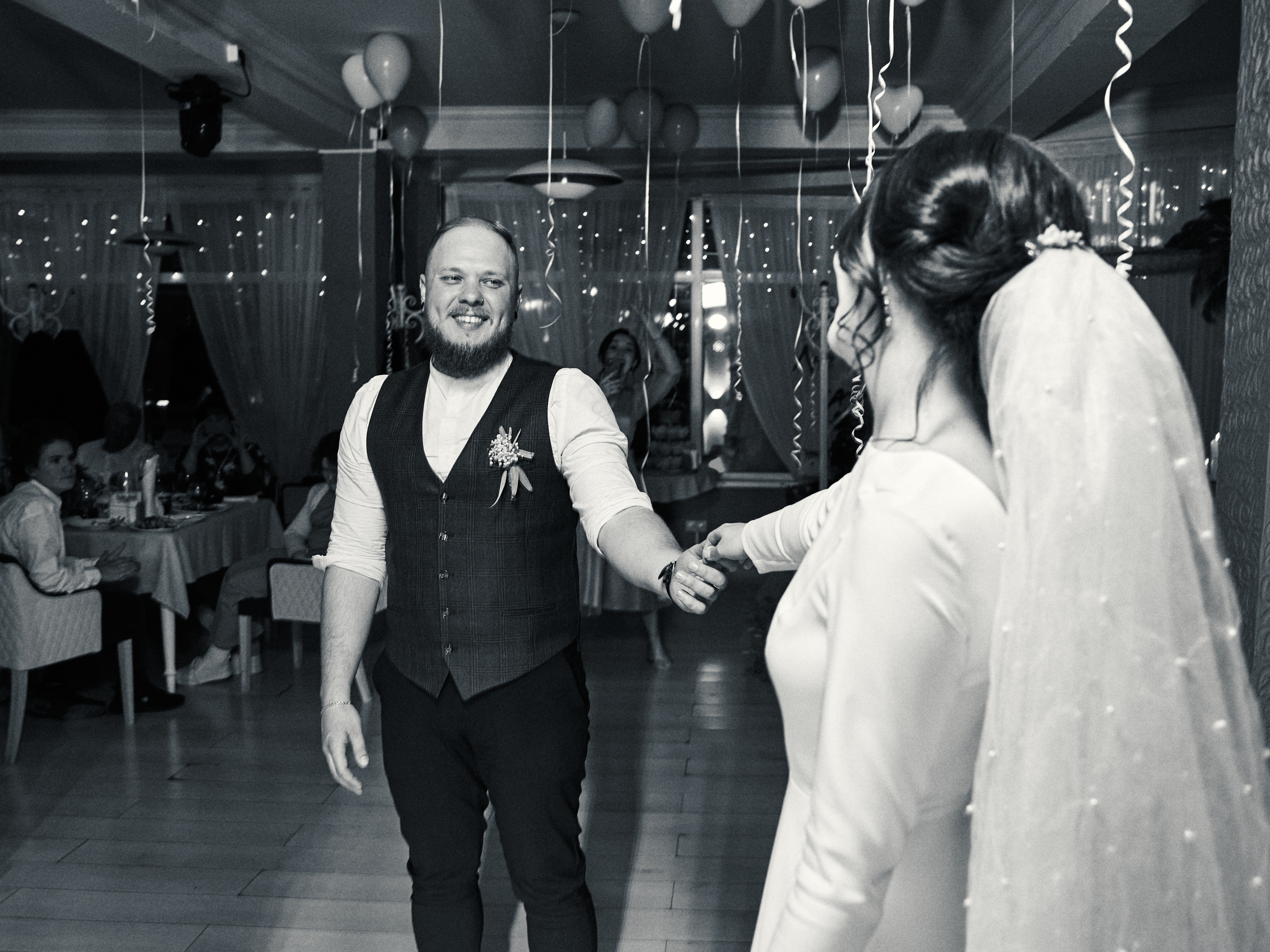 Жених улыбается невесте во время первого танца