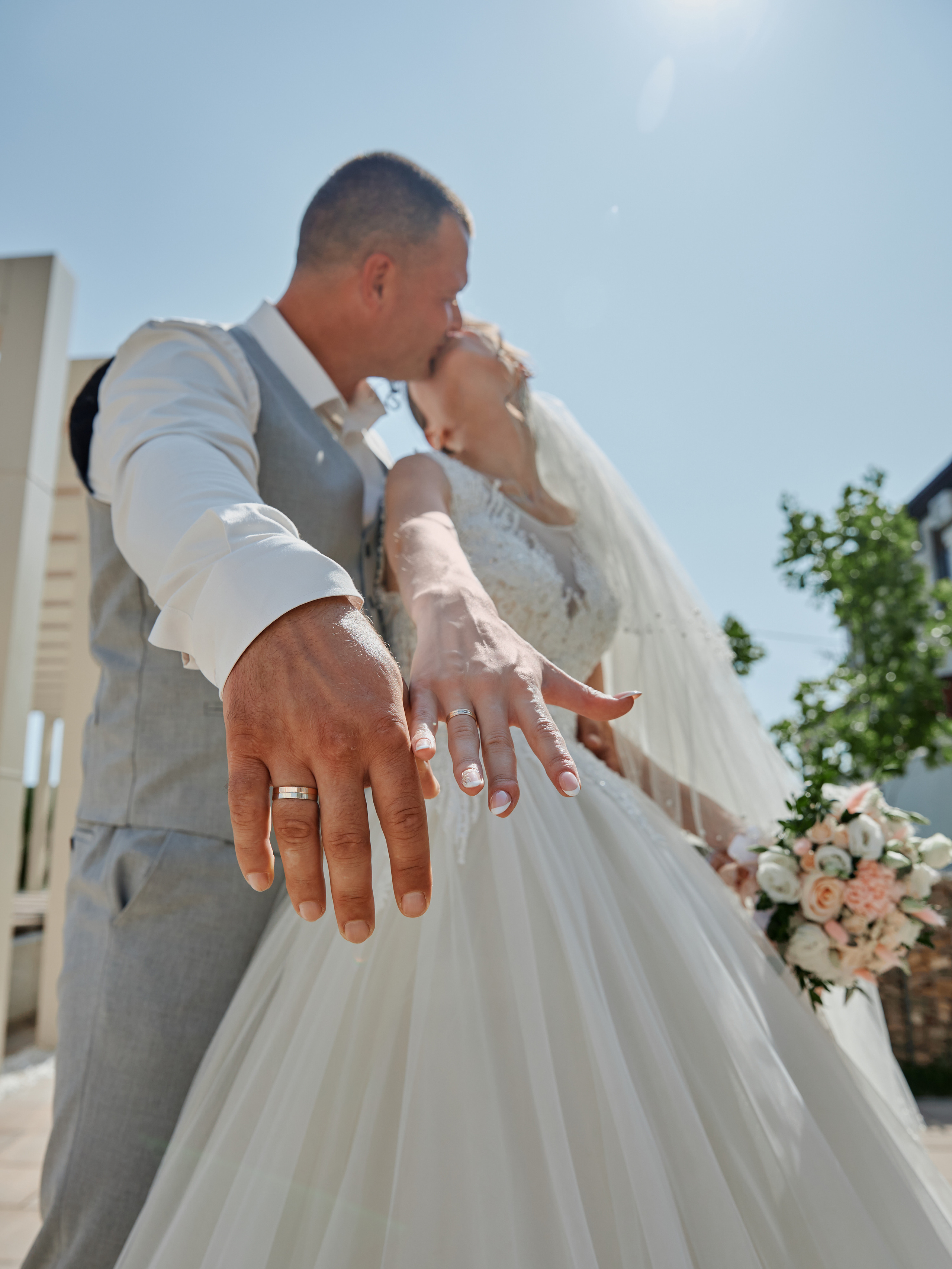 Молодожены показывают кольца в камеру