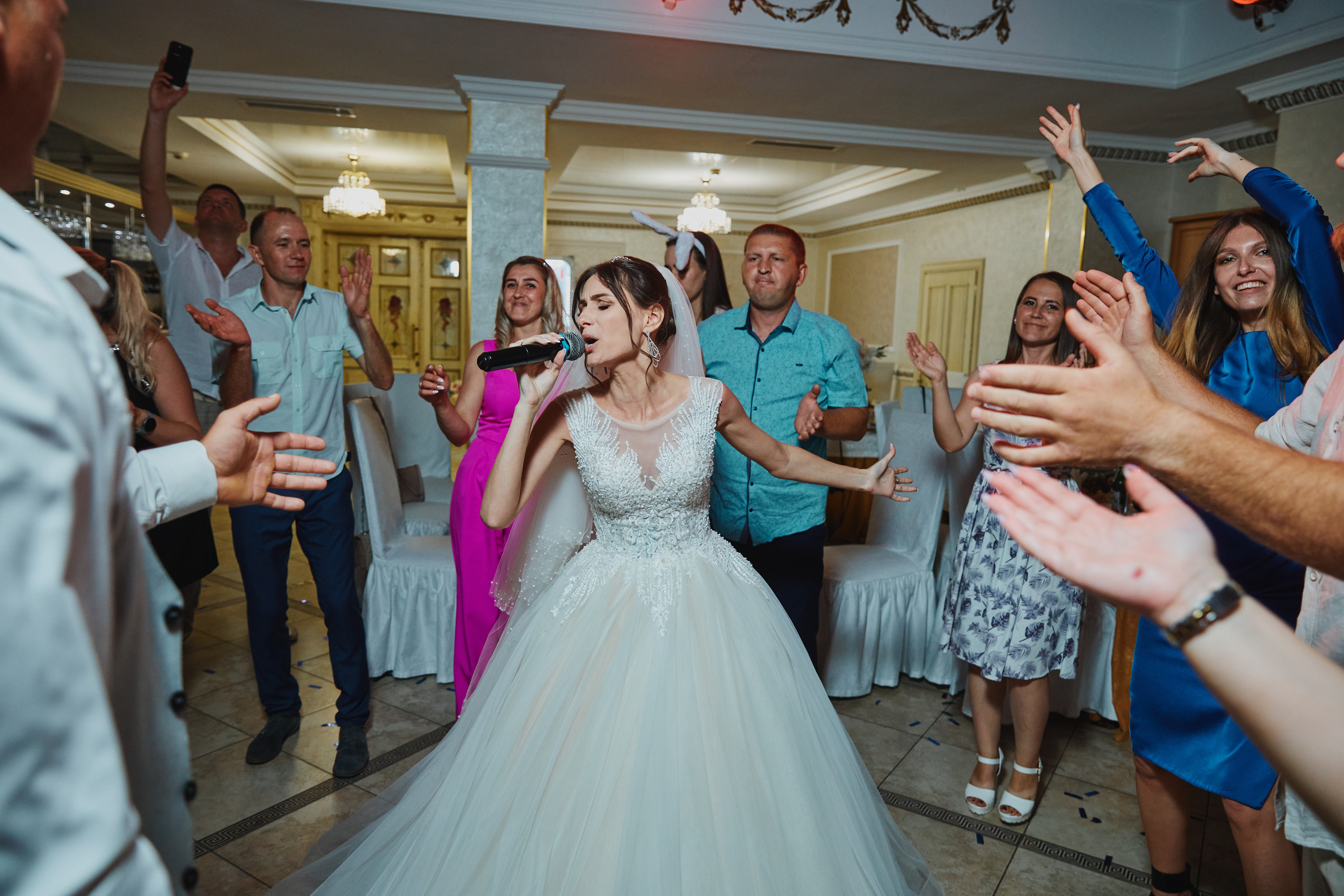 Невеста поет на свадьбе в микрофон