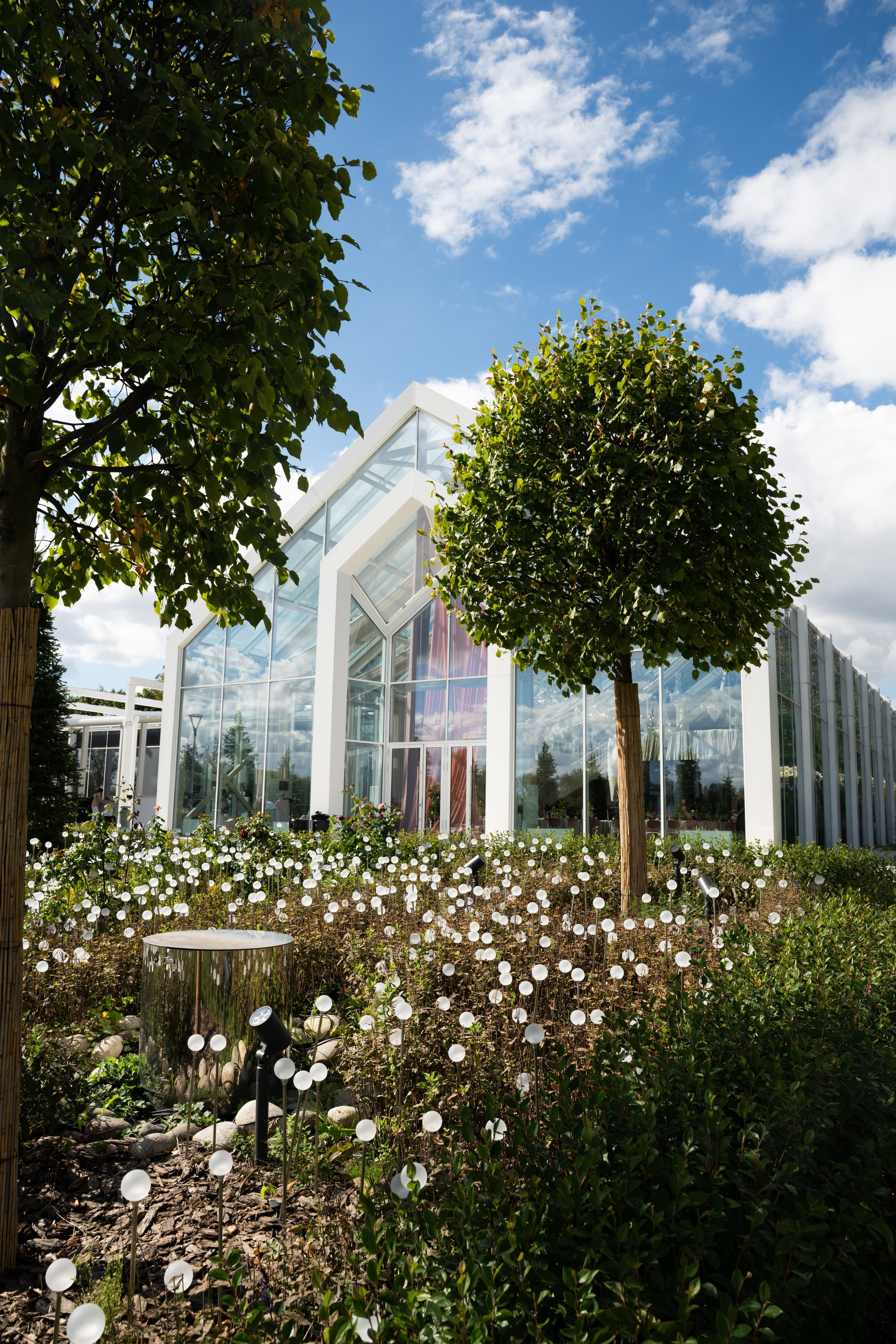 Свадебный павильон Crystal Garden в парке Коломенское среди зелени и цветов.