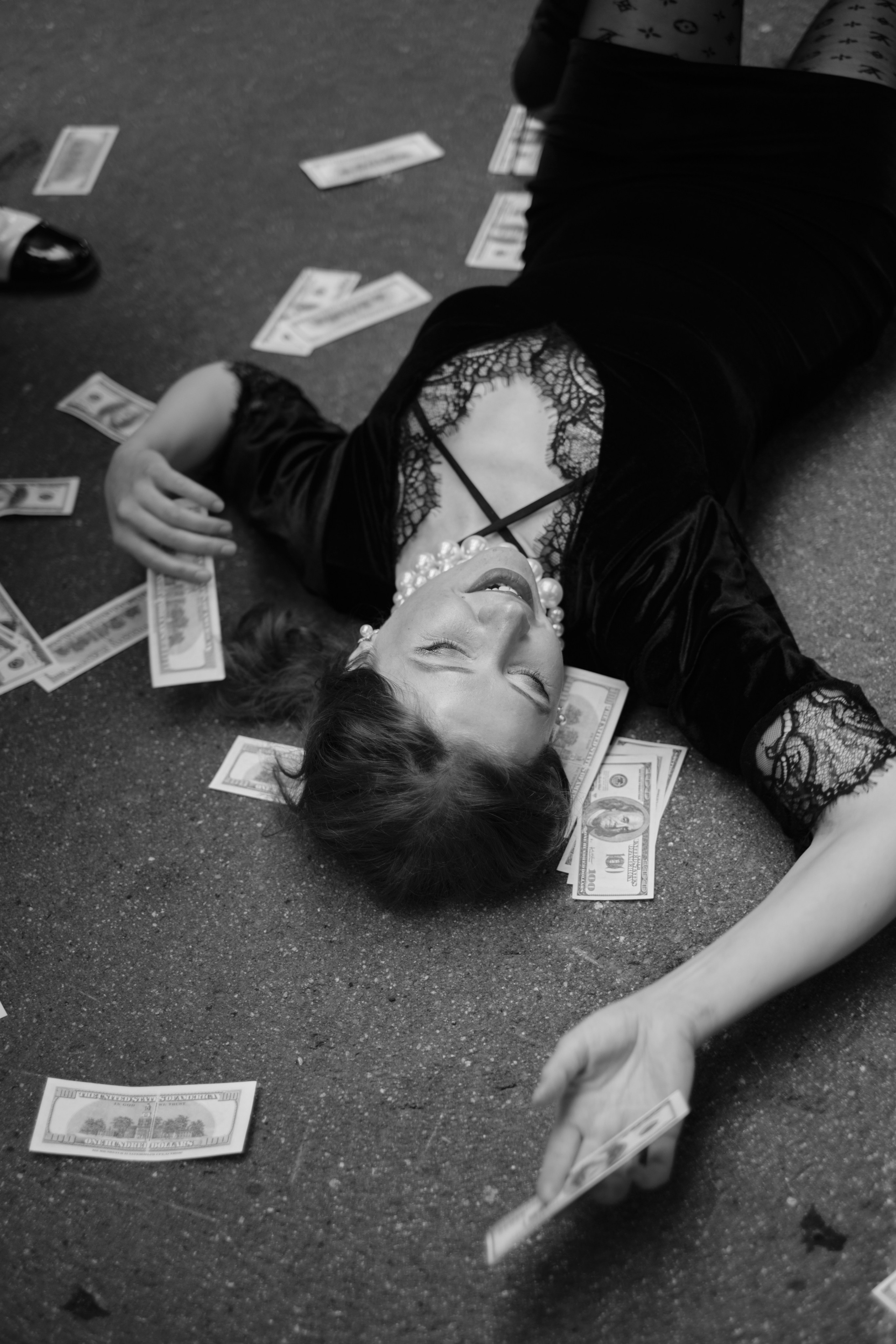 Девушка лежит на асфальте с деньгами