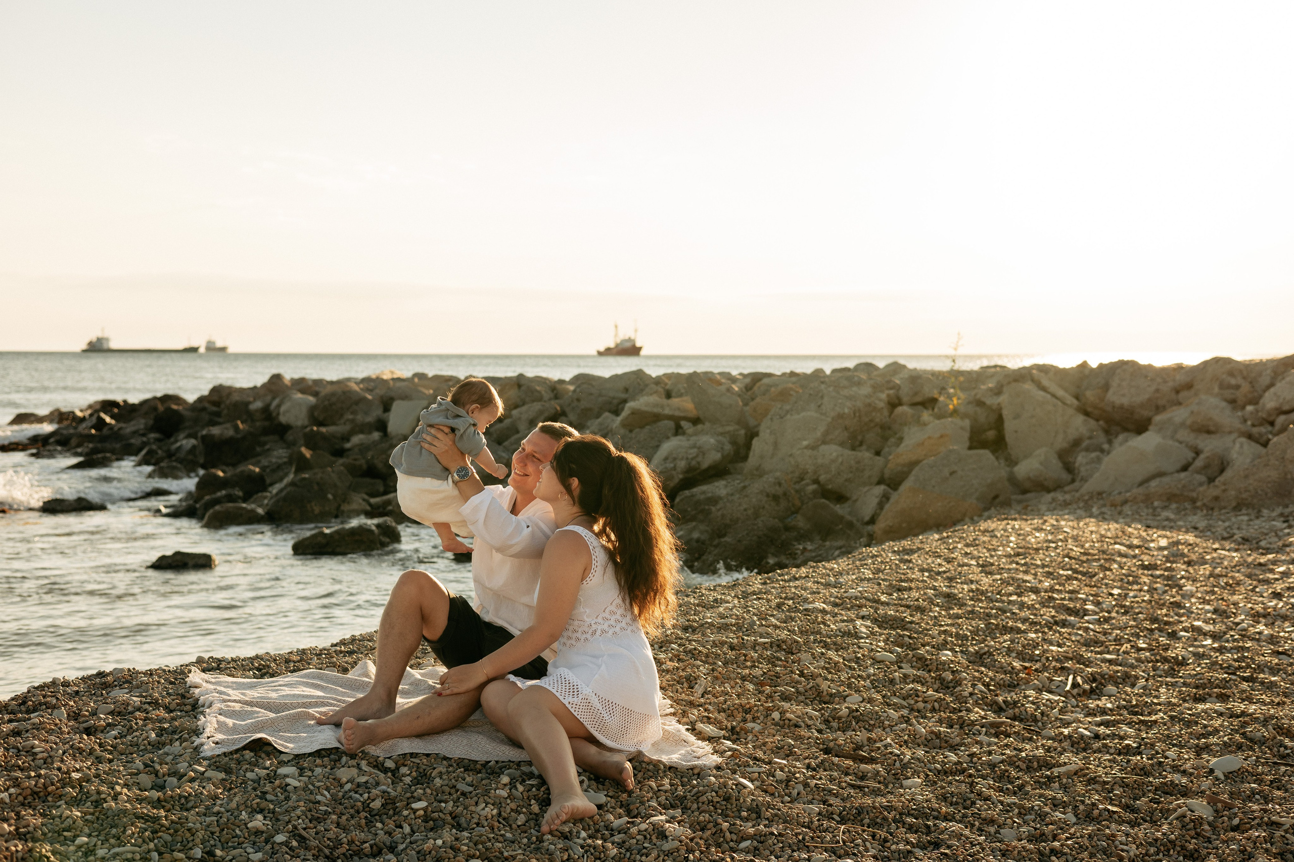 Безмятежность: семья сидит на песке, наблюдая за волнами