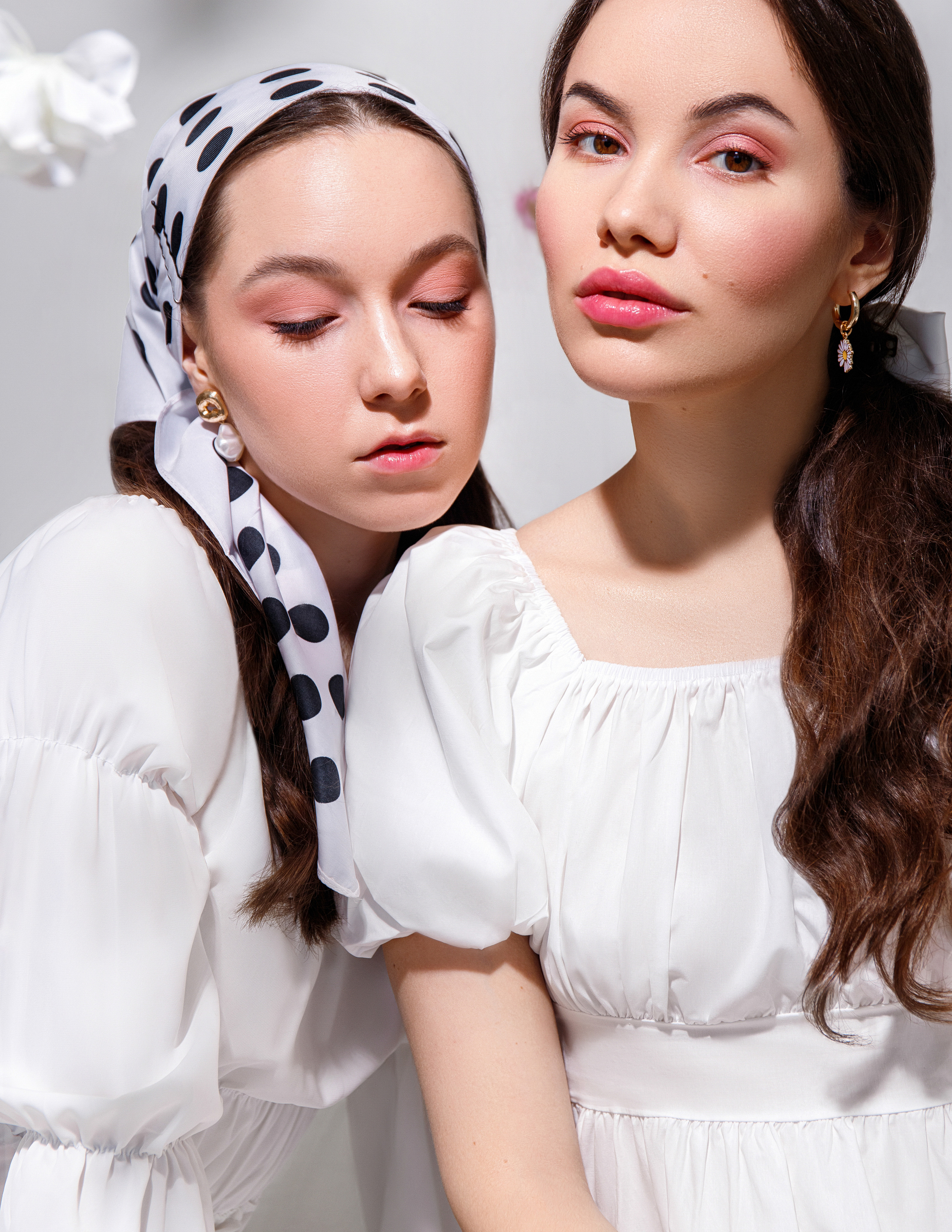 Студийная фотография двух девушек в белых платьях
