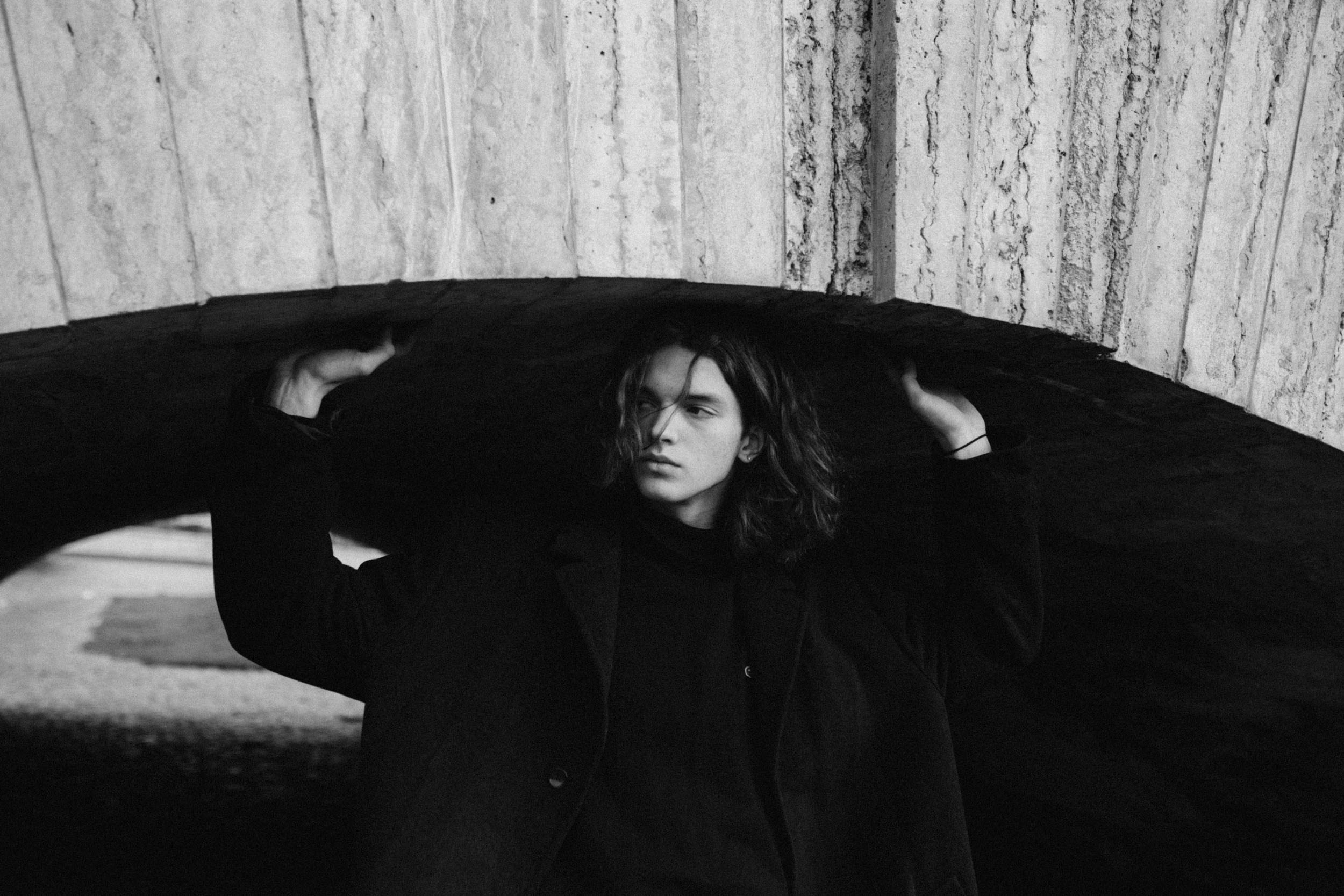 Молодой парень в пальто гуляет по улицам Санкт-Петербурга