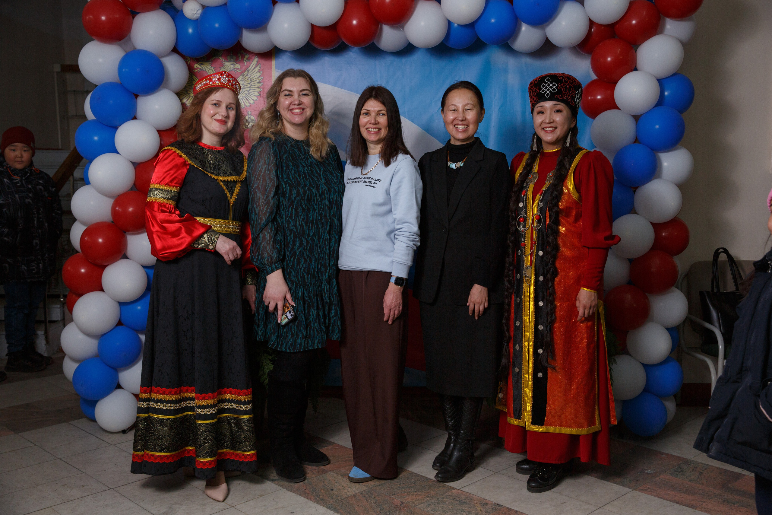 Девушки в национальных костюмах позируют у фотозоны.