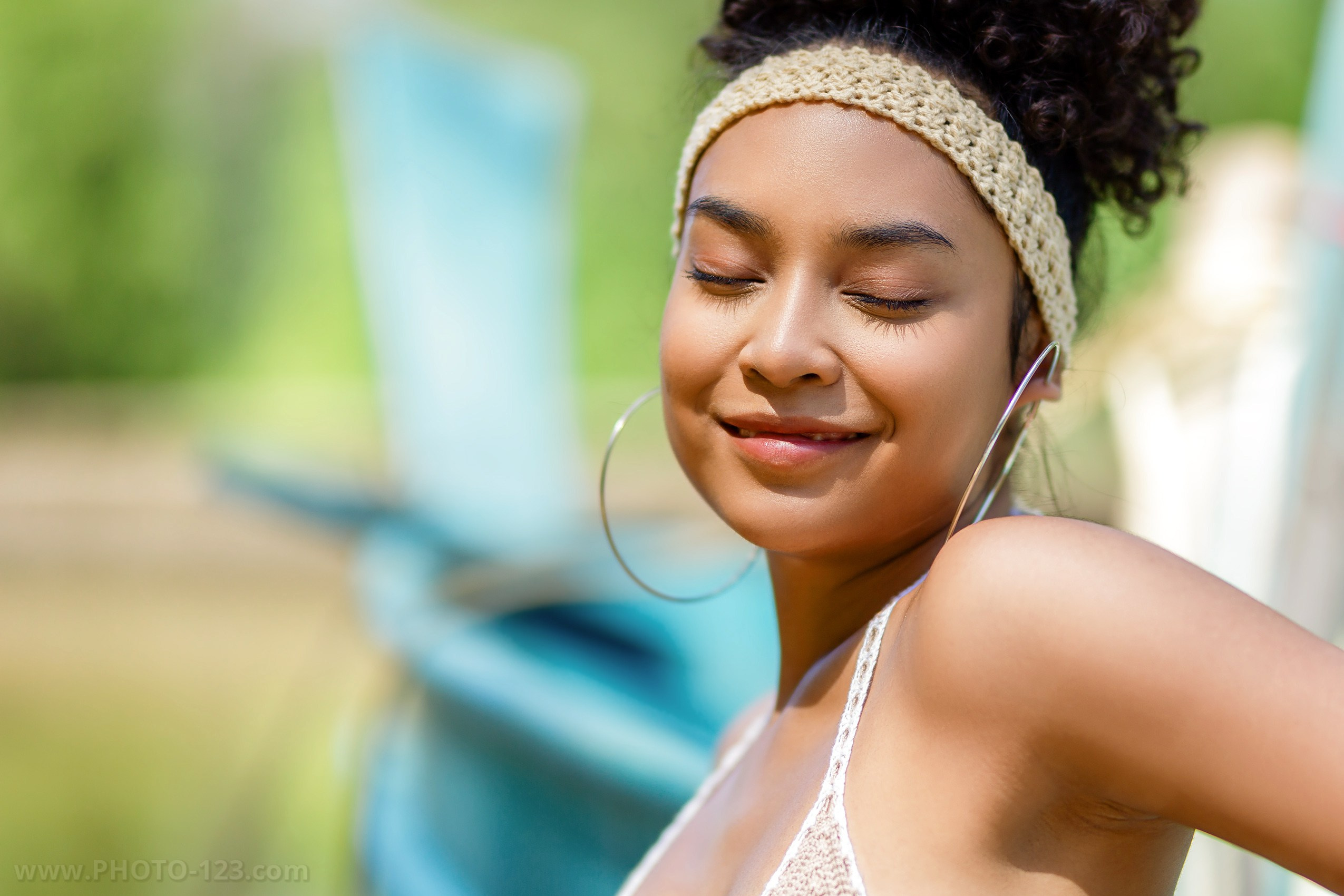 Natural beauty portrait of a woman with curly hair and soft makeup, photographed outdoors in tropical light. Lifestyle and beauty photography on Phu Quoc island, Vietnam by a commercial photographer, ideal for personal portraits, fashion shoots, and brand campaigns