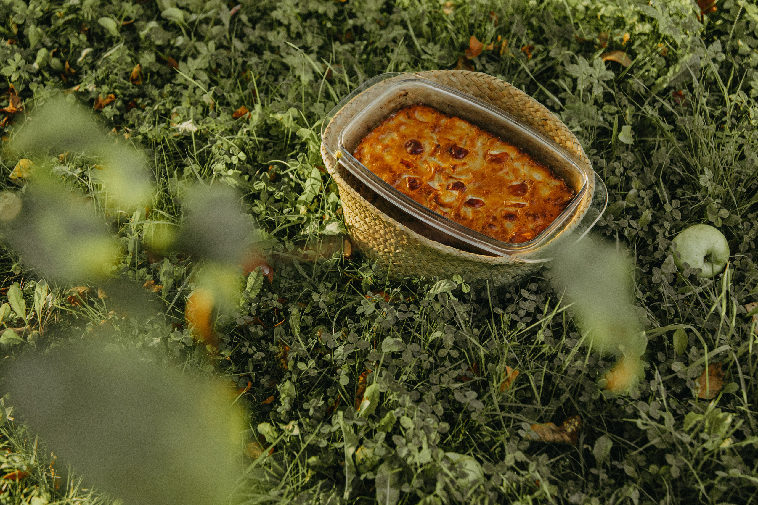 Крупный план яблочной шарлотки на фоне осенних листьев